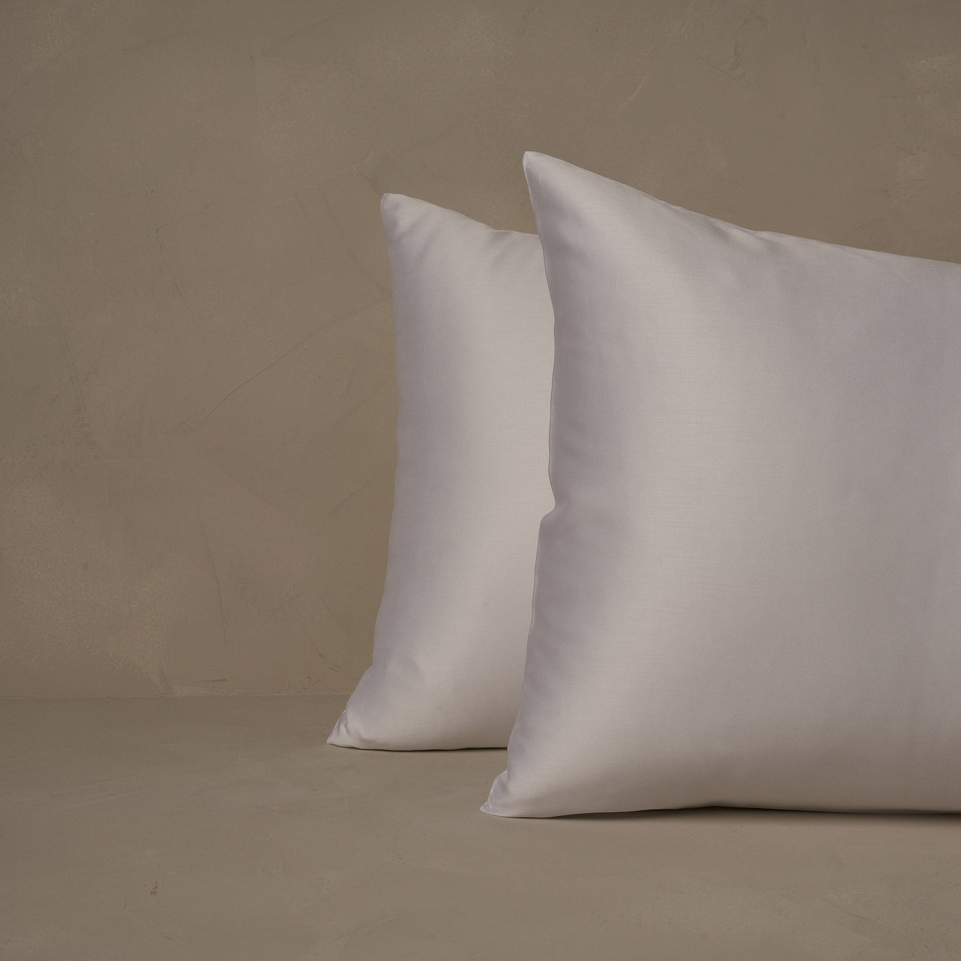 An image of two pillows stacked one in front of the other. The pillow cases are made of LETTO Woodland Silk beechwood modal in color white.