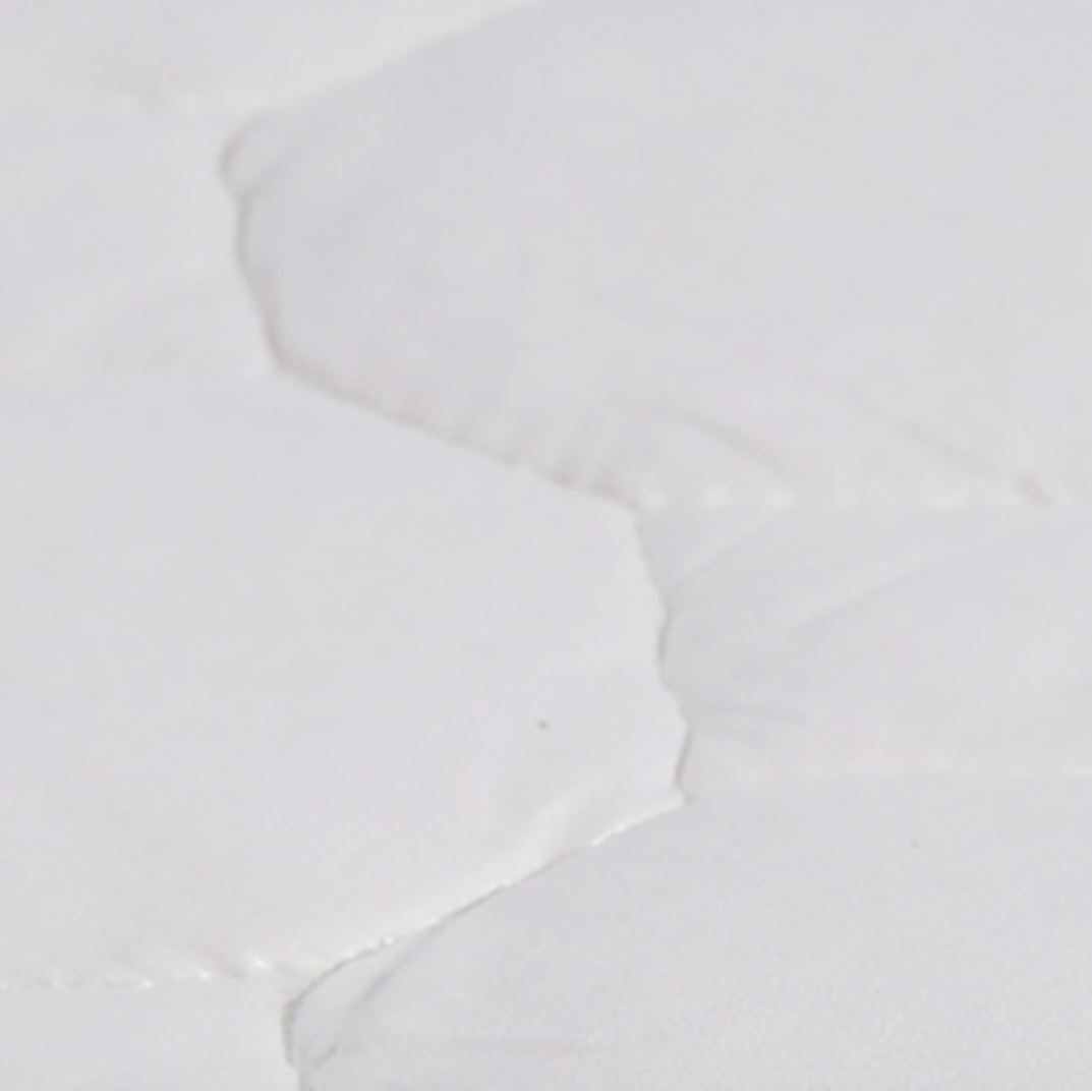 White hexagonal tiles with a subtle pattern on a white background