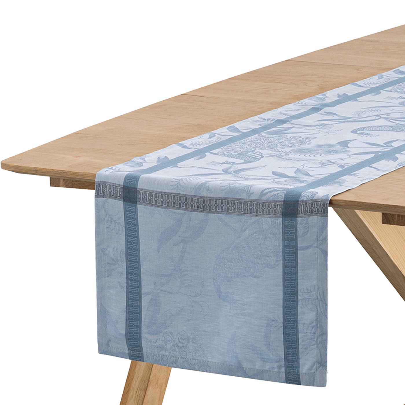 Close-up of steel blue jacquard table runner draped over a natural wood table edge.