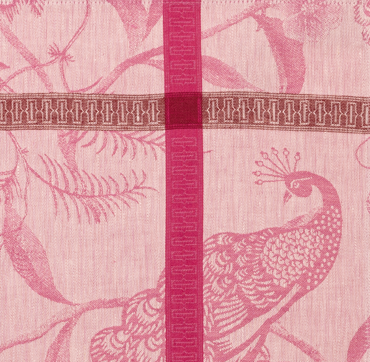 Close-up of rose jacquard weave with peacock motif and fuchsia striped border detail.