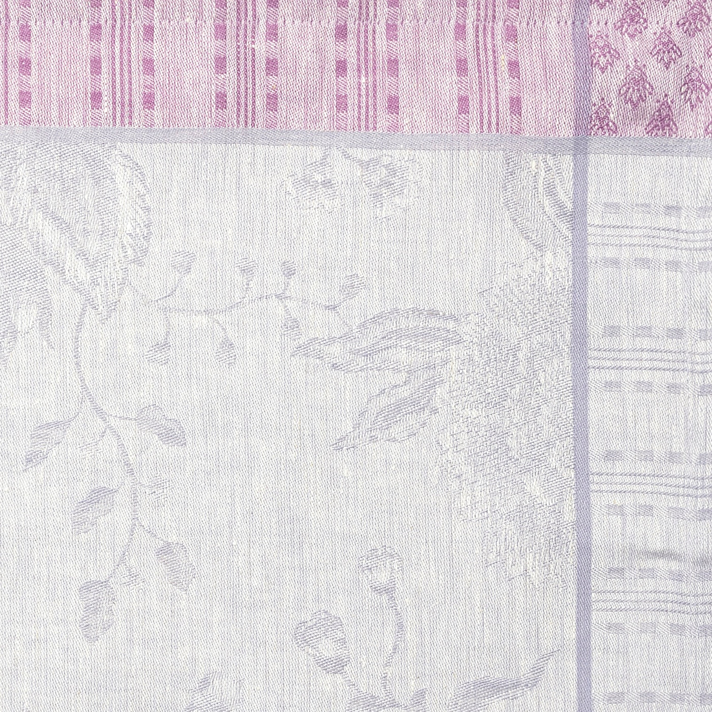 Close-up of Été Indien tablecloth showing woven floral jacquard in lilac and rose.