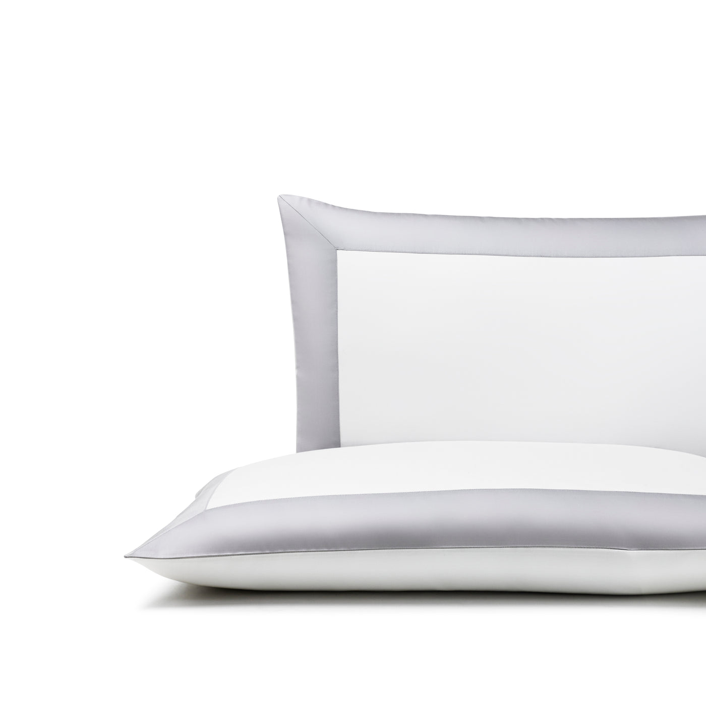 The Frette Bold | Sleeping Sham, a white cotton sateen pillowcase with a wide light gray satin border, lies on a white surface against a plain background, highlighting its classic style and perfect sham sizing.
