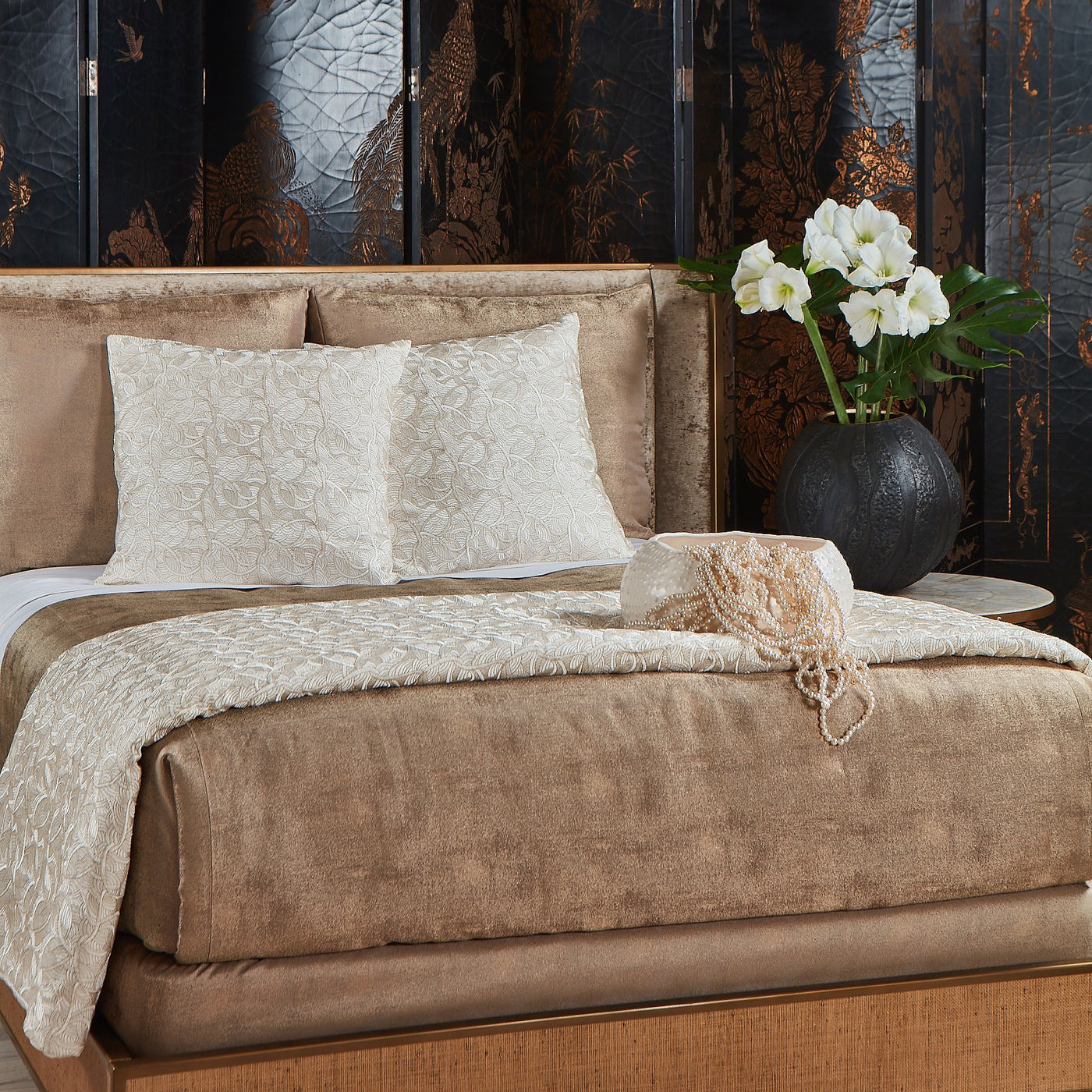 Ann Gish La Sirene ivory embroidered pillow styled on a camel velvet bed.