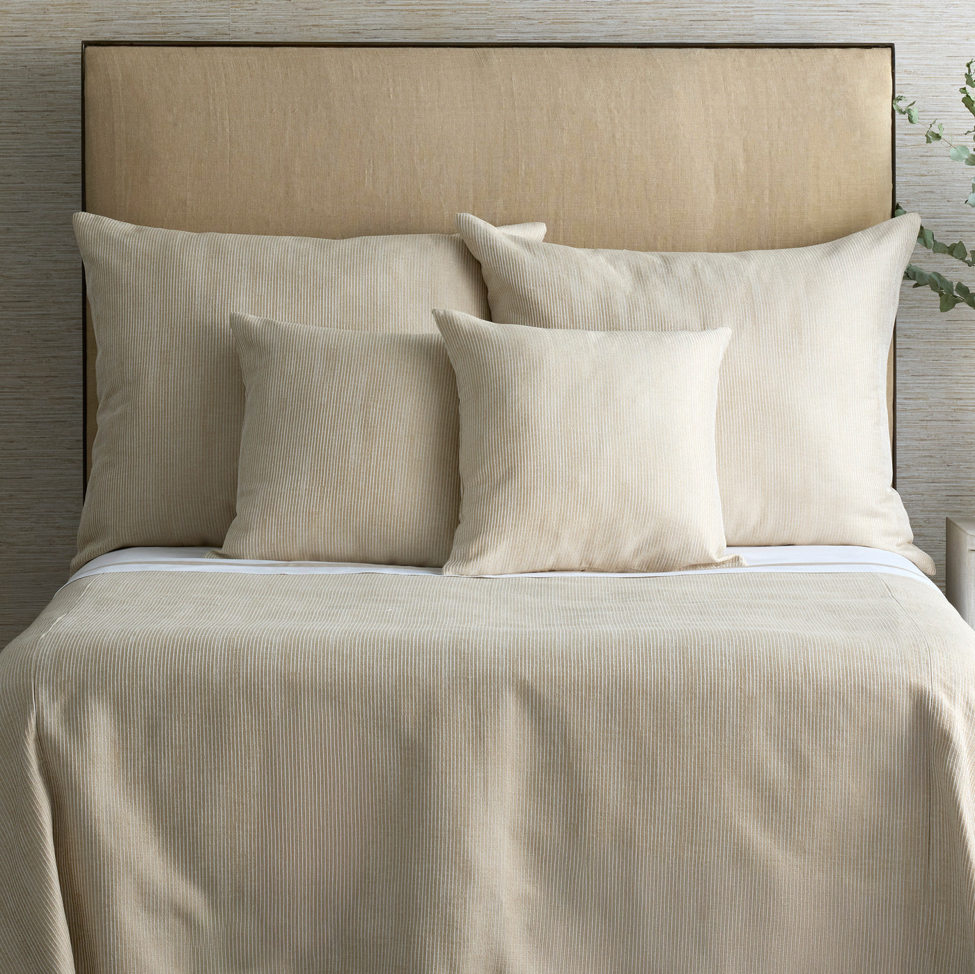 Ann Gish Lamina coverlet in champagne, styled on bed with matching shams.