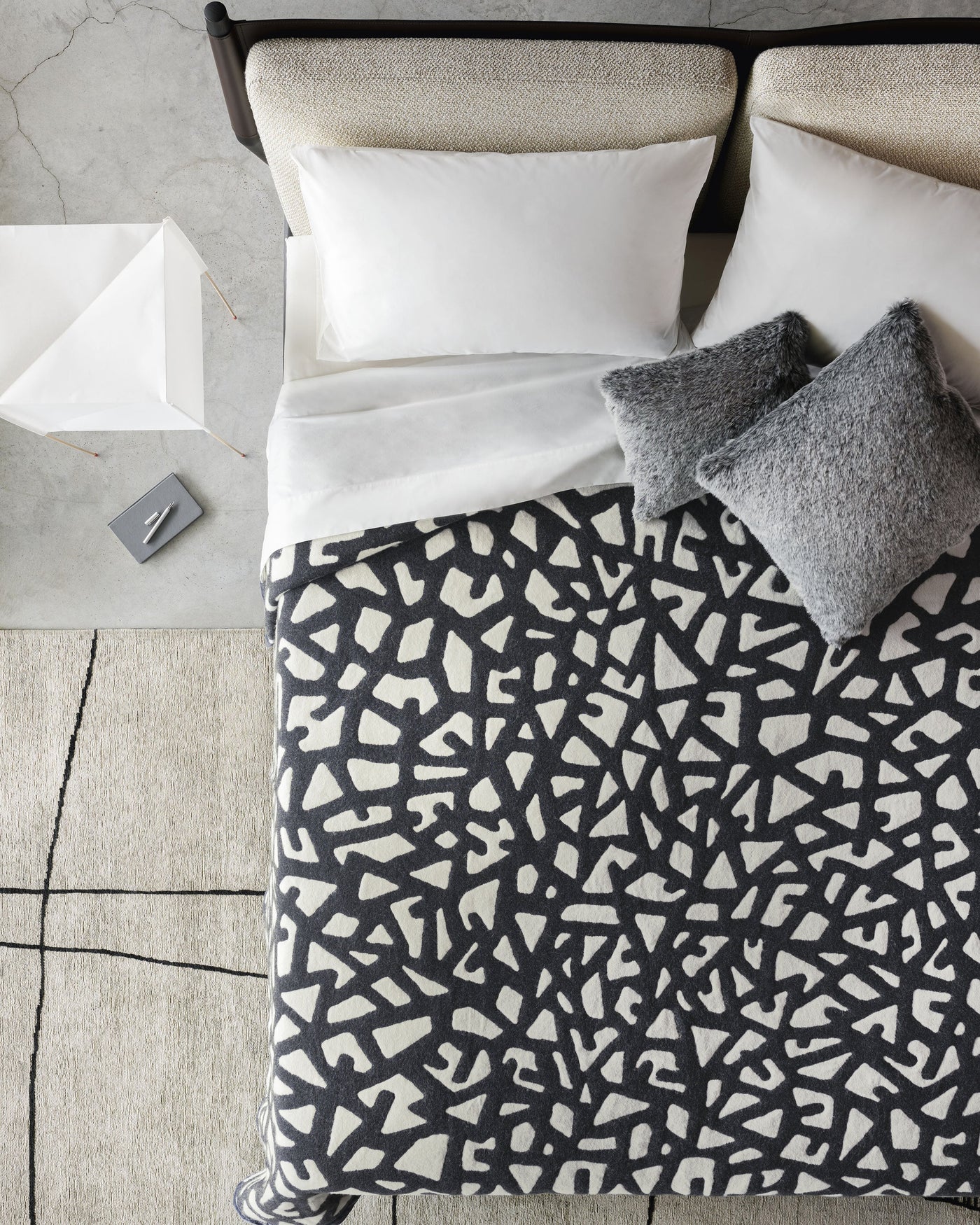 Lanerossi Tribal Thermo Blanket in charcoal and ivory abstract pattern, styled on bed, overhead view.