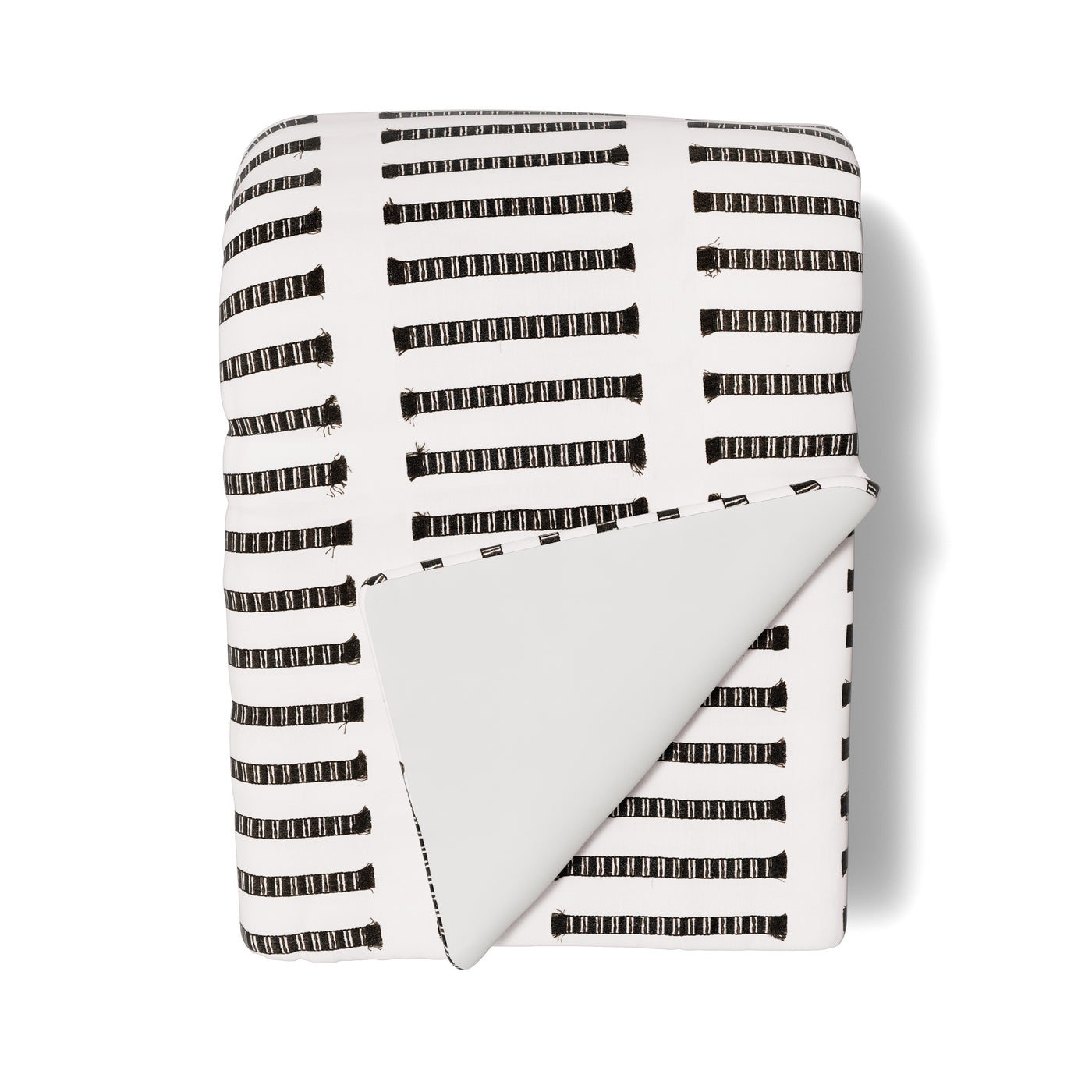 Close-up of Ann Gish Latera throw folded, white with black dashed stripe pattern, solid reverse.