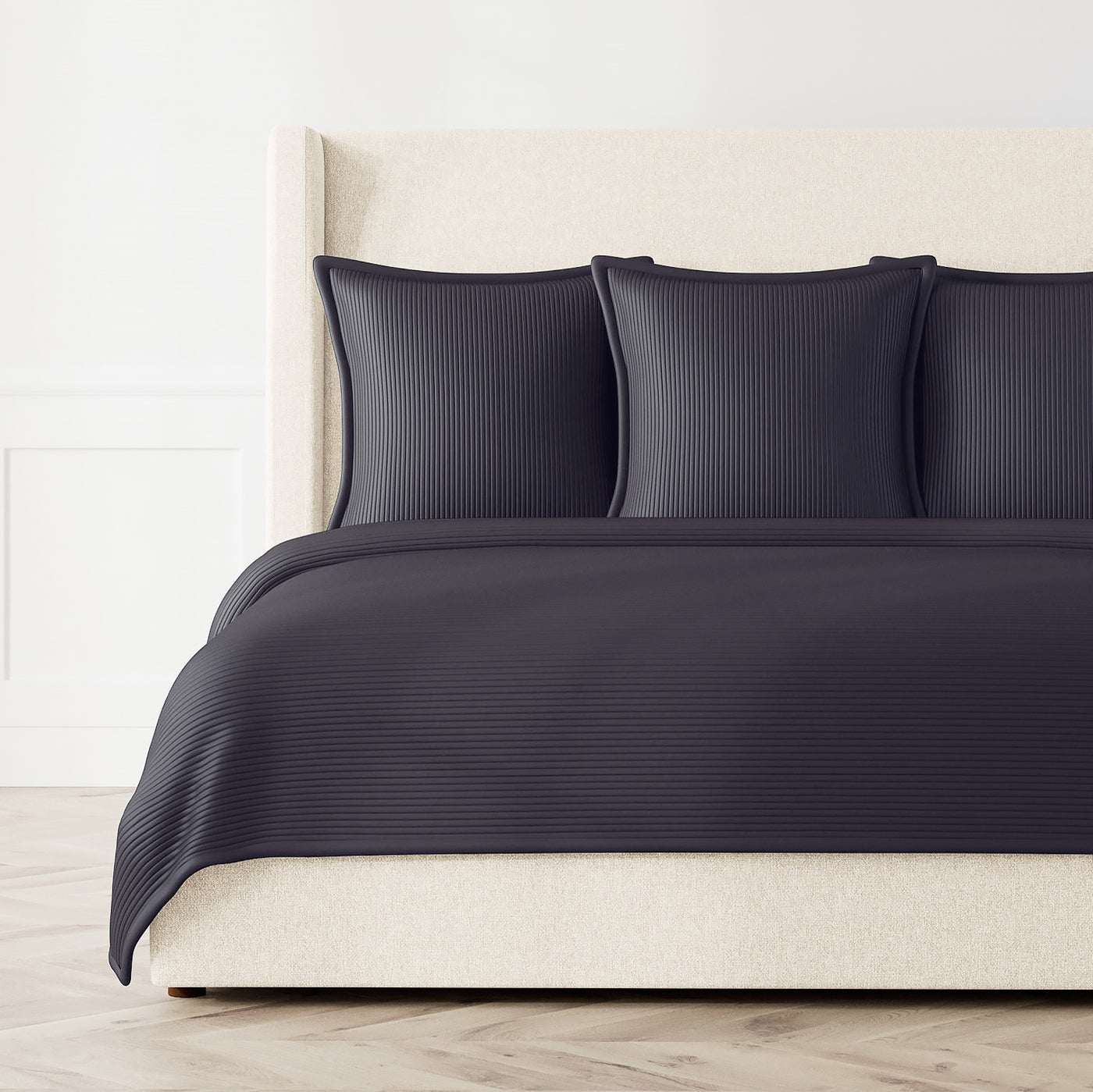 Ann Gish Linea coverlet set in navy with tonal stripe texture, styled on a bed.