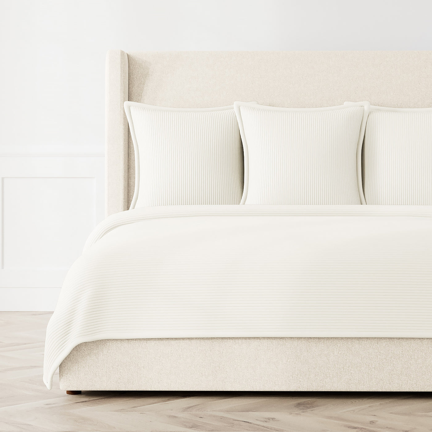 Ann Gish Linea coverlet set in ivory, styled on a bed with matching shams, ribbed texture detail.
