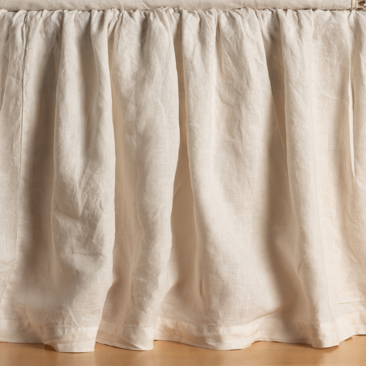 Gathered Natural linen bed skirt with soft draping folds, close-up front view.
