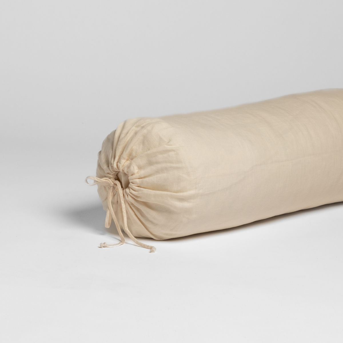 Close-up of Bella Notte Linen throw pillow in Natural, gathered drawstring end detail.