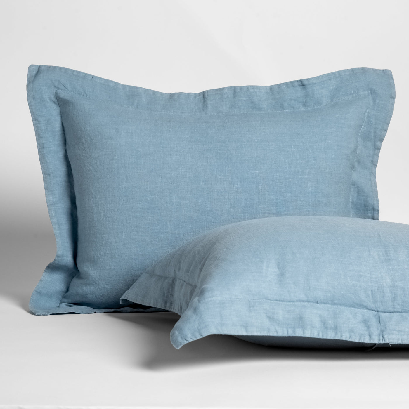 Tahoe Blue linen shams stacked, showing flanged edge detail on textured woven fabric.