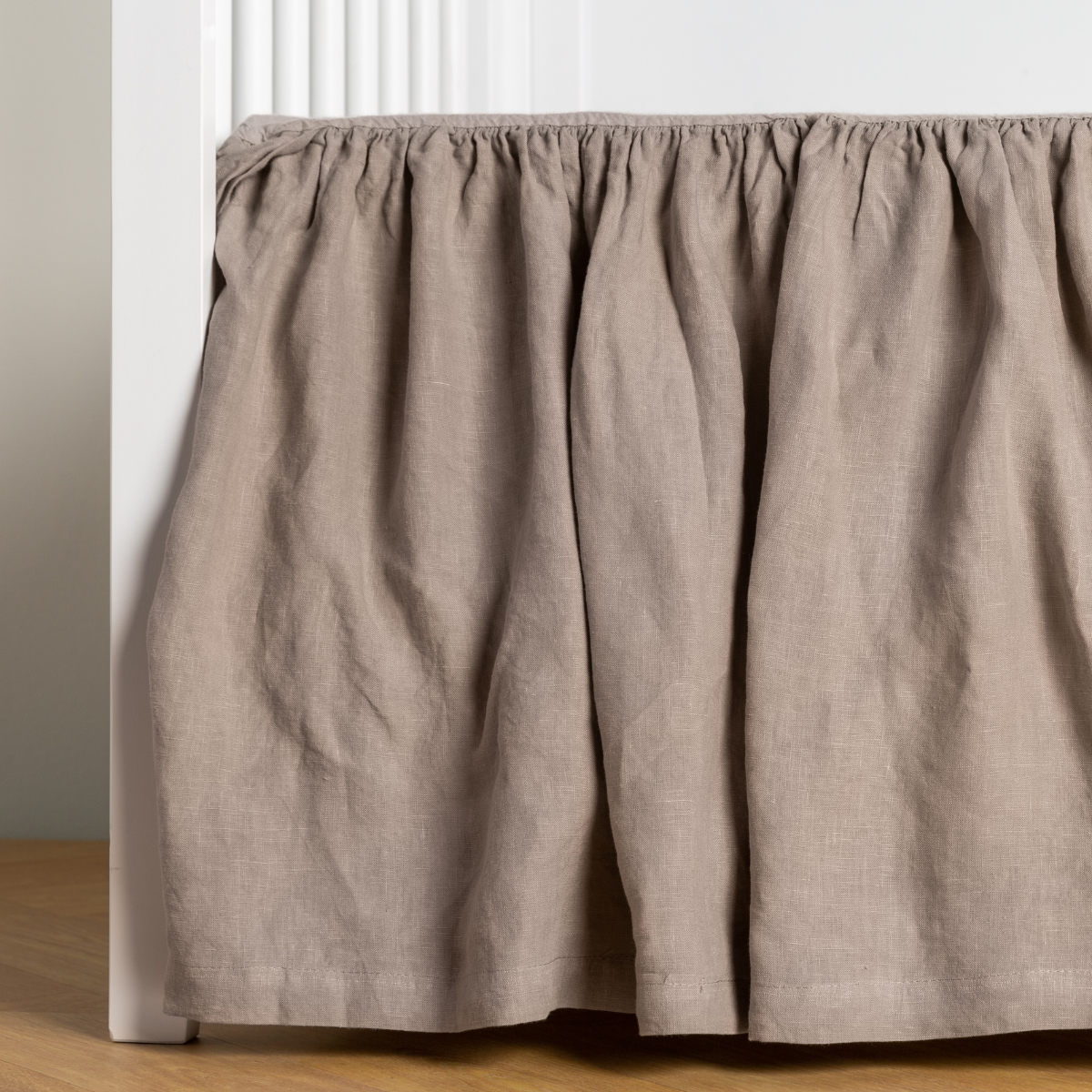 Fog linen crib skirt with gathered ruffle, styled on a white crib frame.