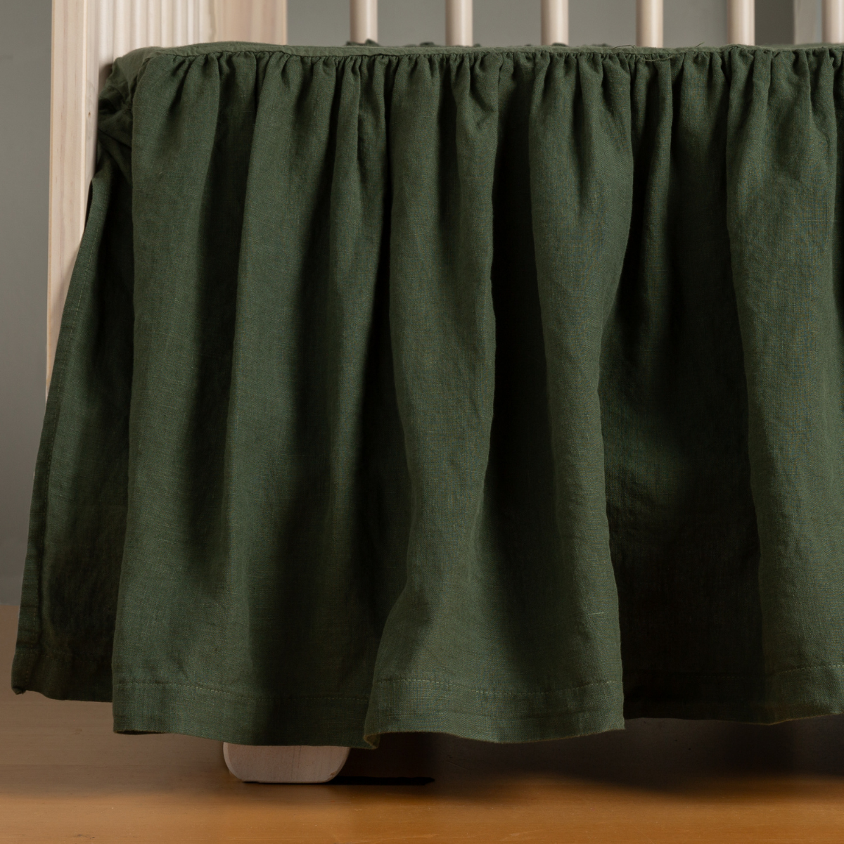 Juniper linen crib skirt with gathered ruffle, close view of drape and texture.