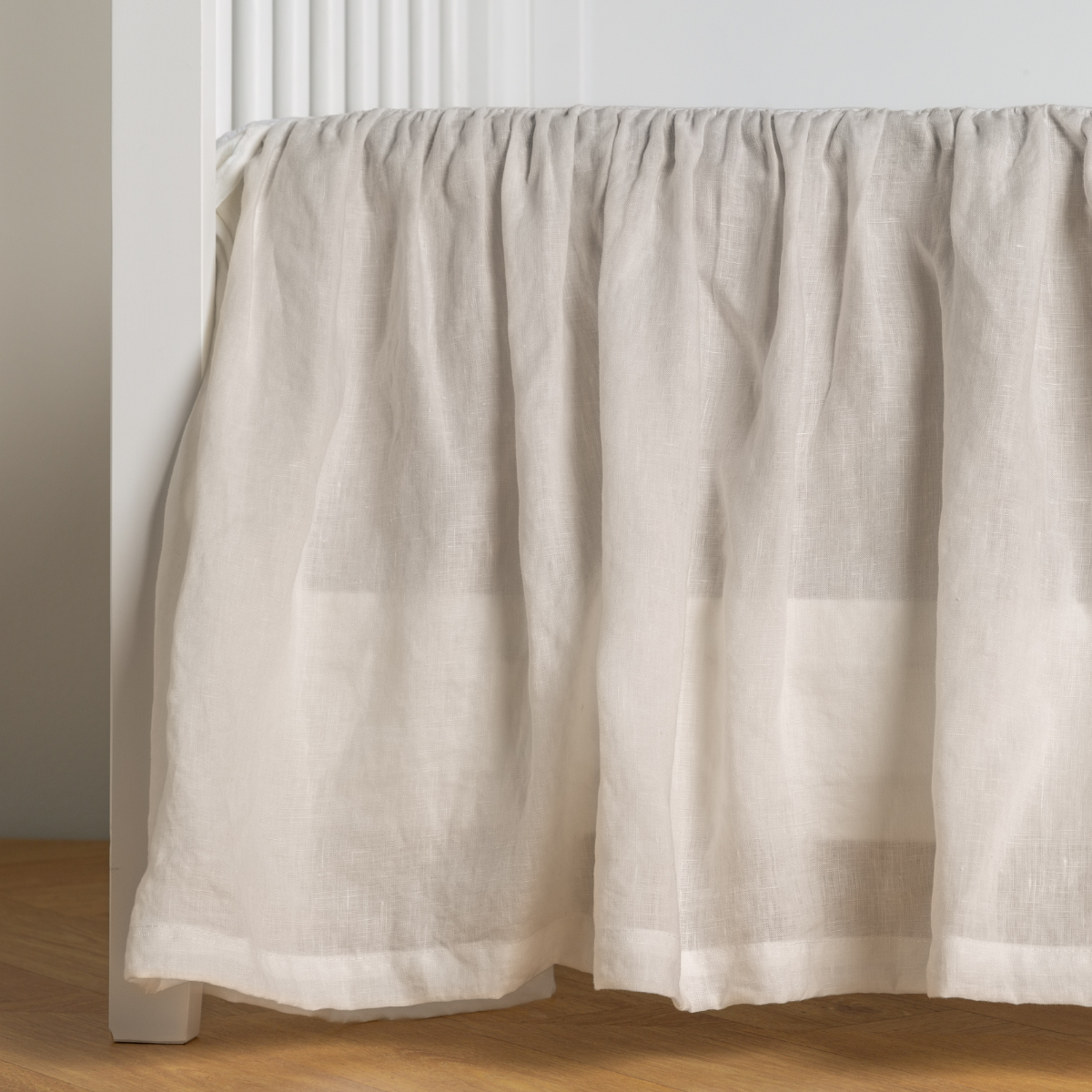 Bella Notte linen crib skirt in Winter White, gathered ruffle detail with soft drape.