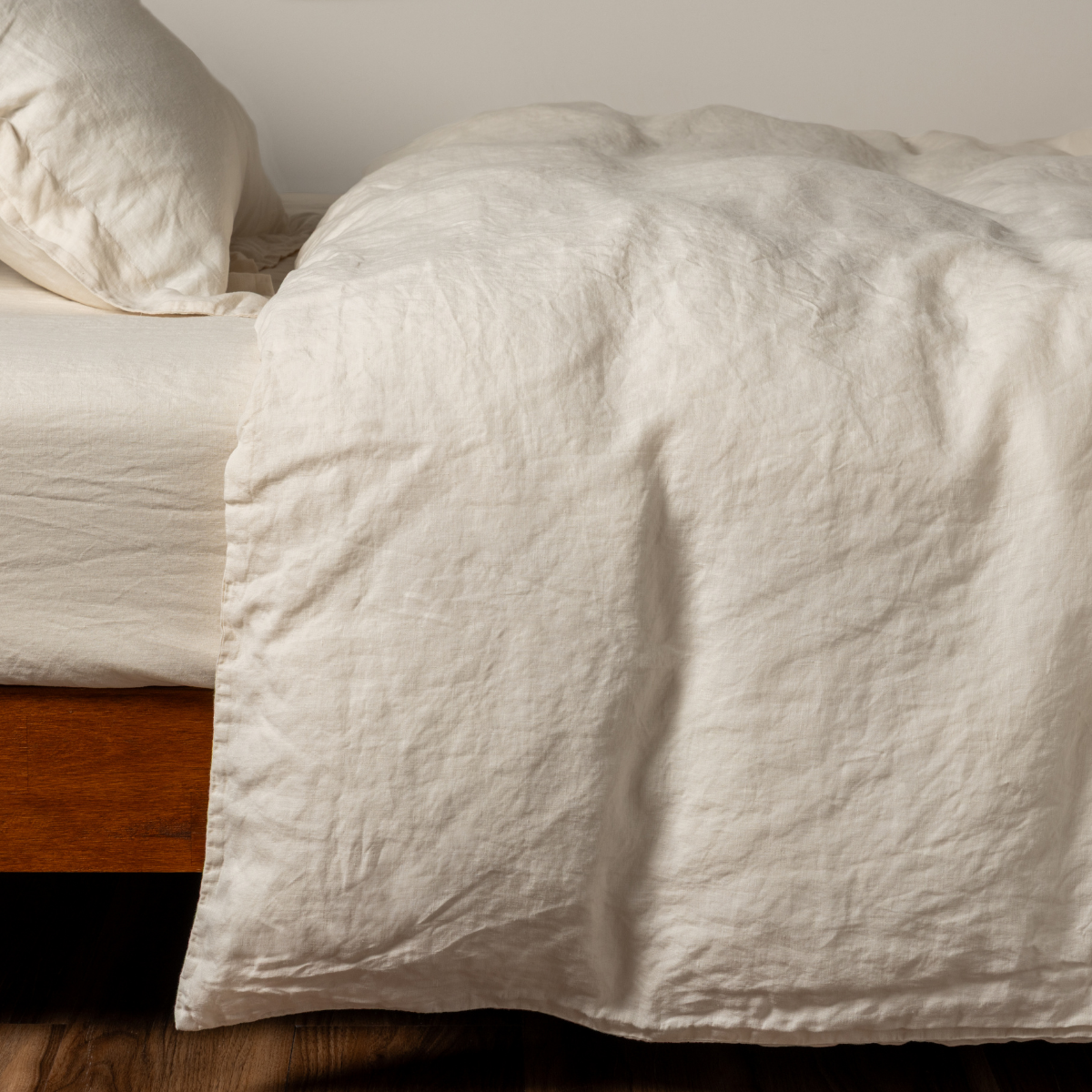 Bella Notte Natural linen duvet cover draped over bed, showing relaxed texture and soft drape.