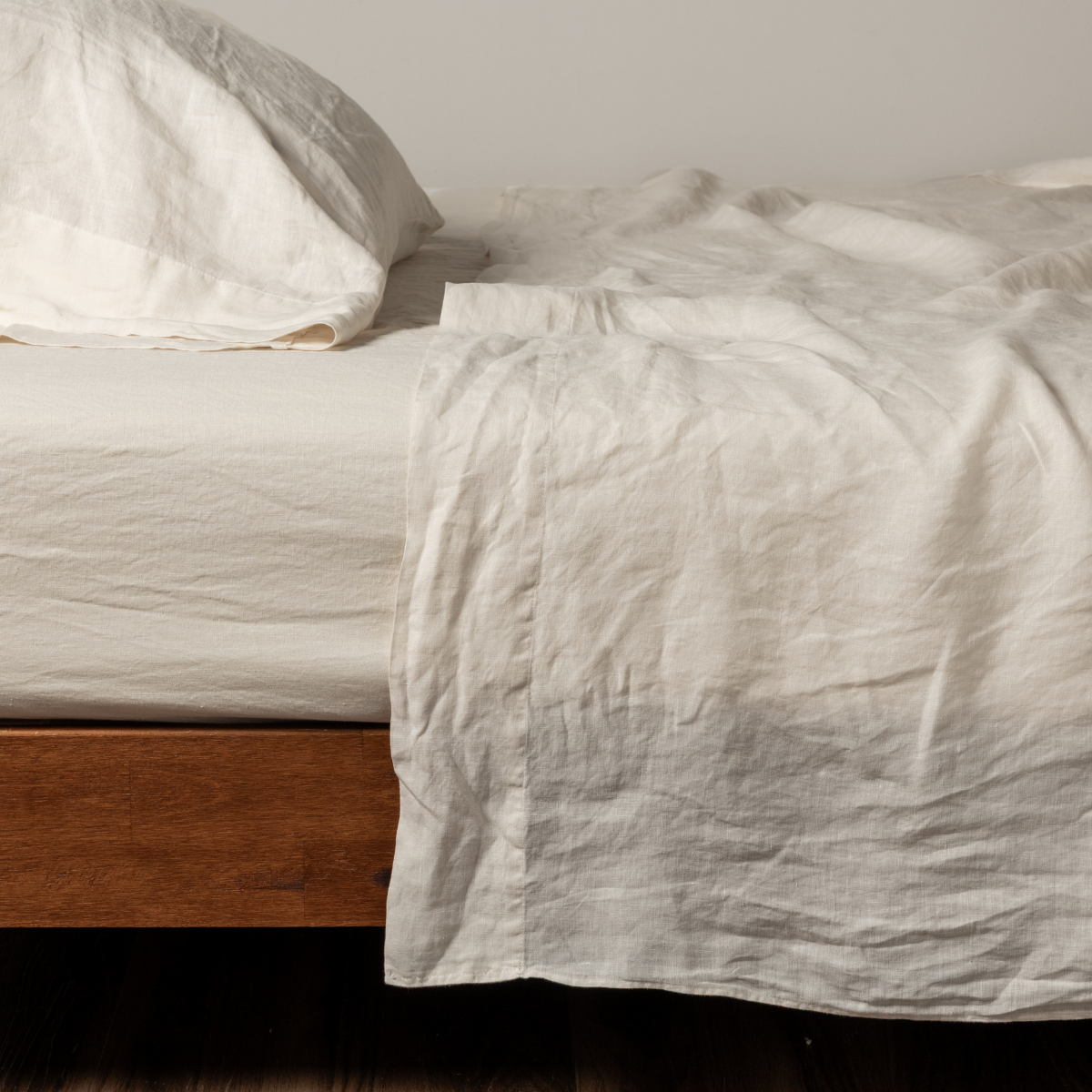 Bella Notte Linen flat sheet in Natural, draped over bed with relaxed texture visible.