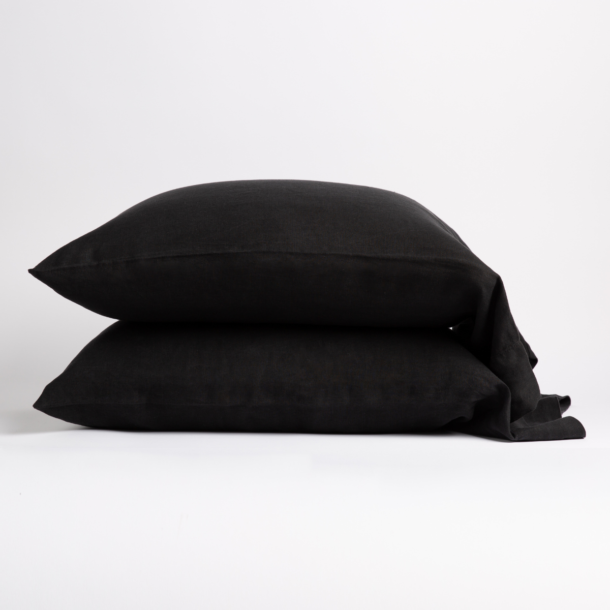 Bella Notte Linen pillowcases stacked in Corvino, showing relaxed drape and envelope closure.