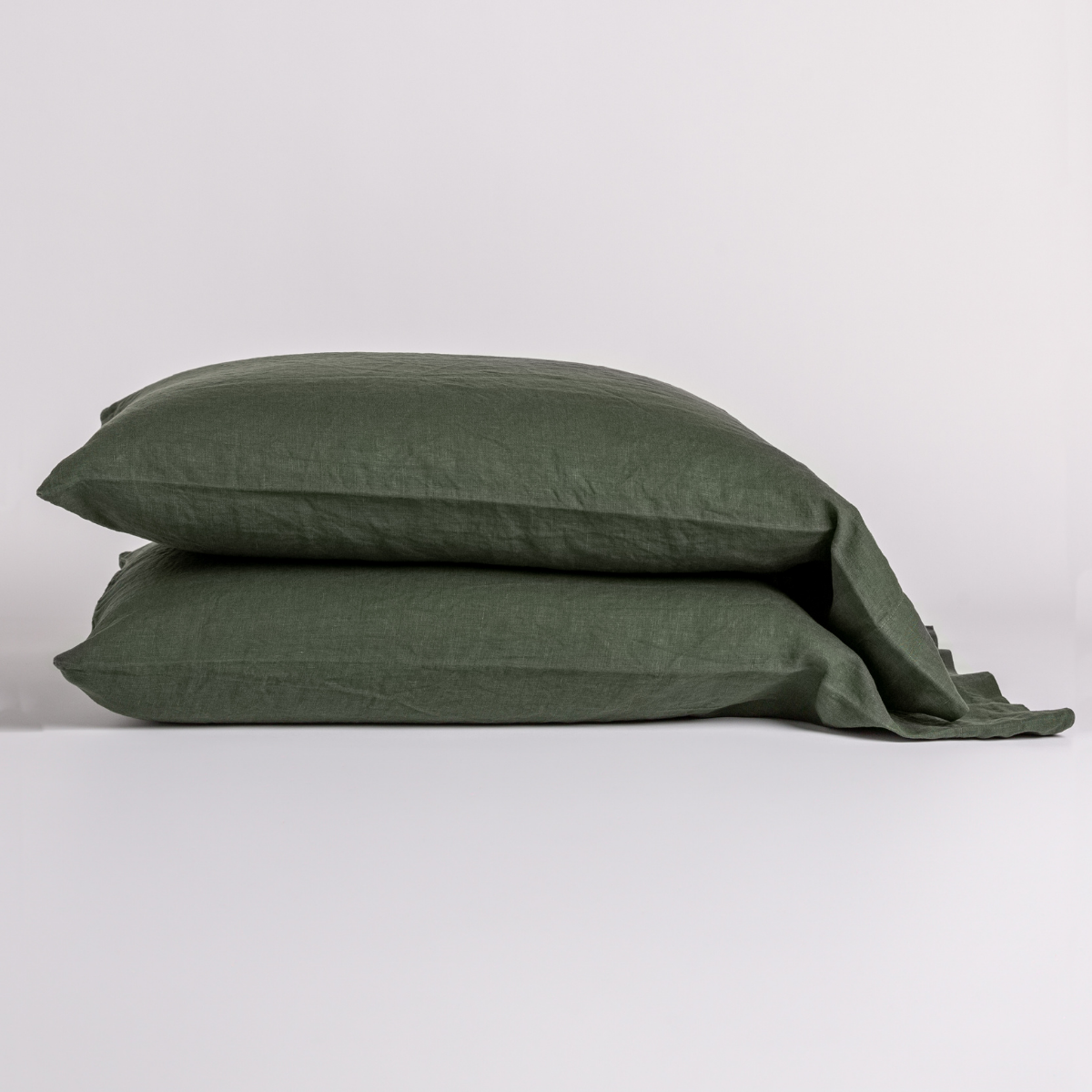 Two Bella Notte Linen pillowcases stacked in Juniper, showing relaxed washed texture.