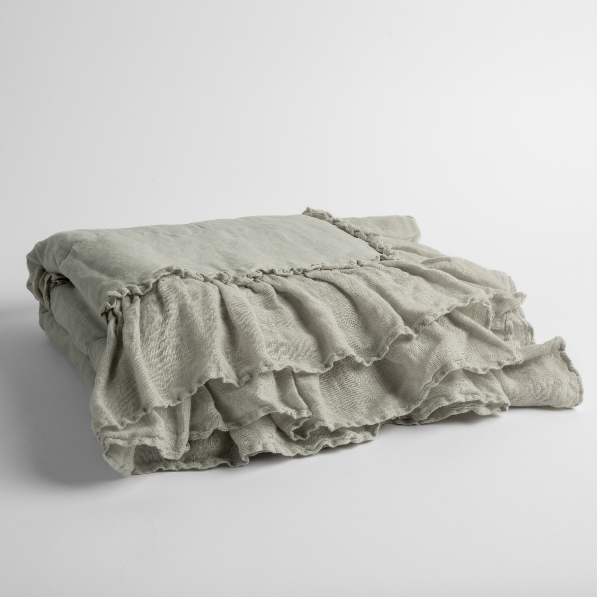 Folded Cloud linen baby blanket showing layered ruffle trim detail.