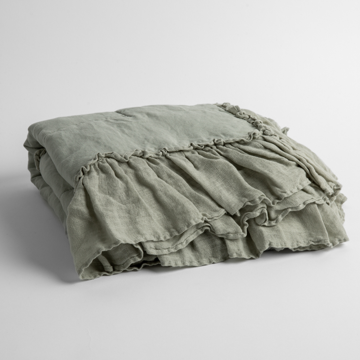 Folded Eucalyptus linen baby blanket showing ruffled trim detail.