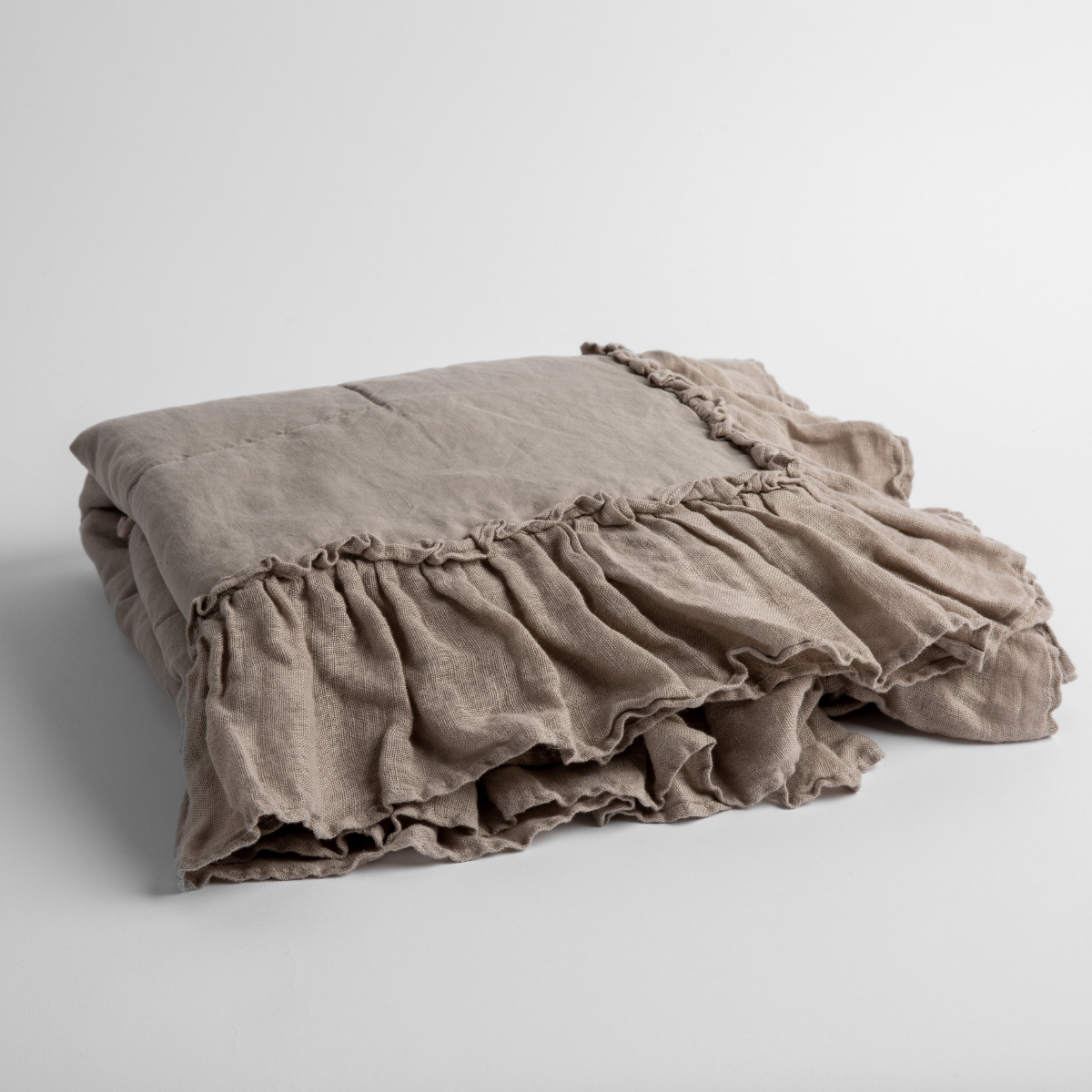 Bella Notte Linen Whisper baby blanket in Fog, folded to show ruffled trim detail.