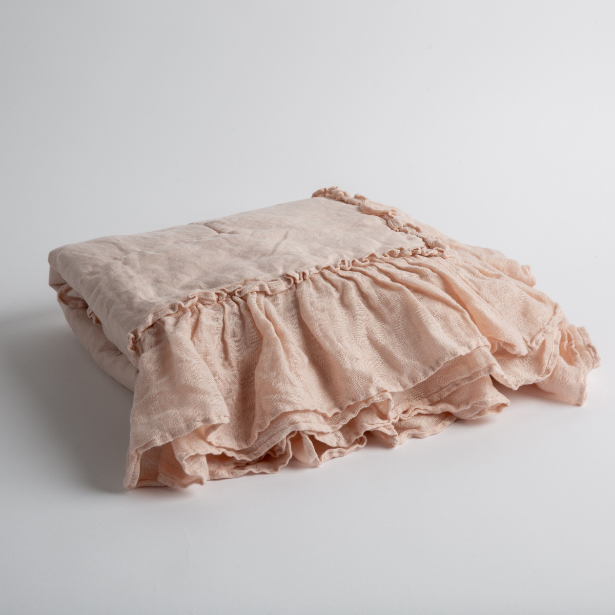 Bella Notte Linen Whisper baby blanket in Pearl, folded to show ruffled trim detail.