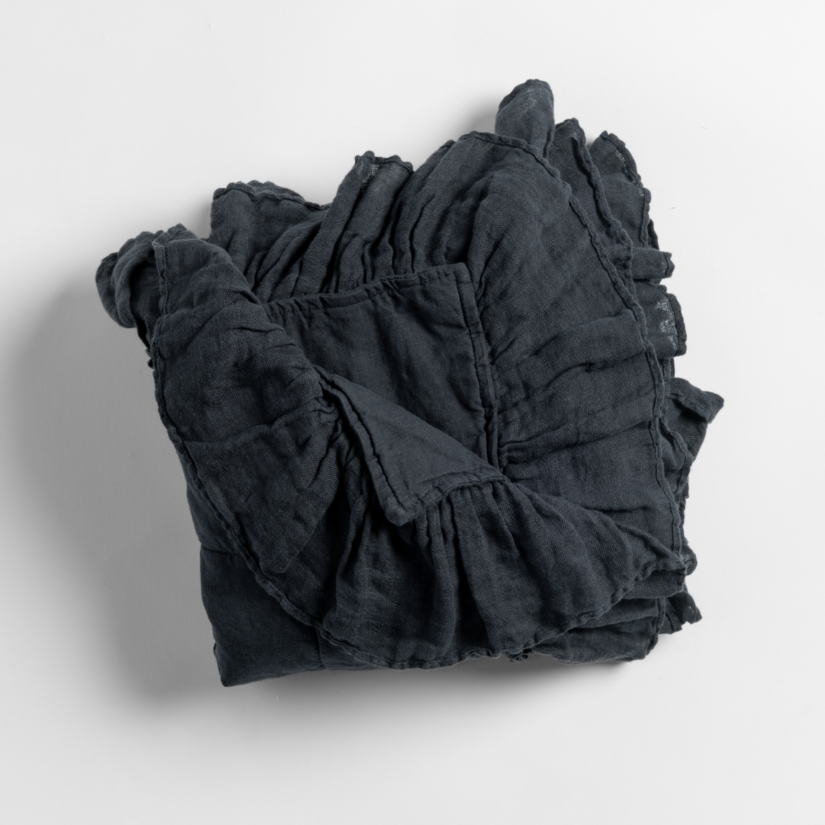 Bella Notte Linen Whisper baby blanket in Slate, folded to show ruffled linen trim detail.