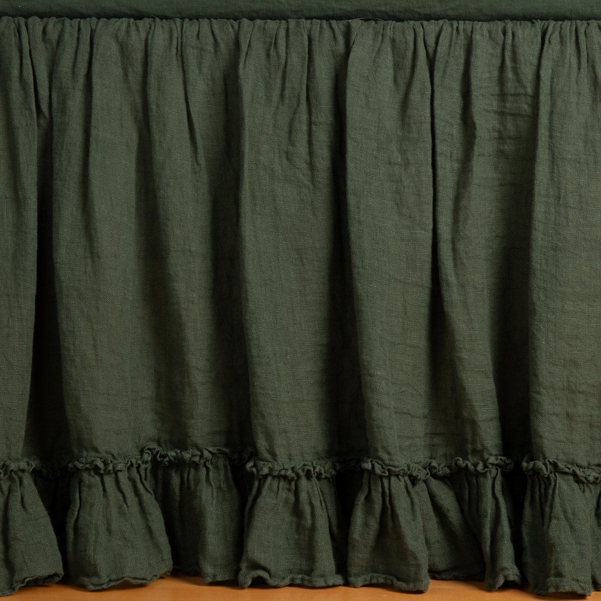 Bella Notte Linen Whisper bed skirt in Juniper, showing ruffled hem detail.