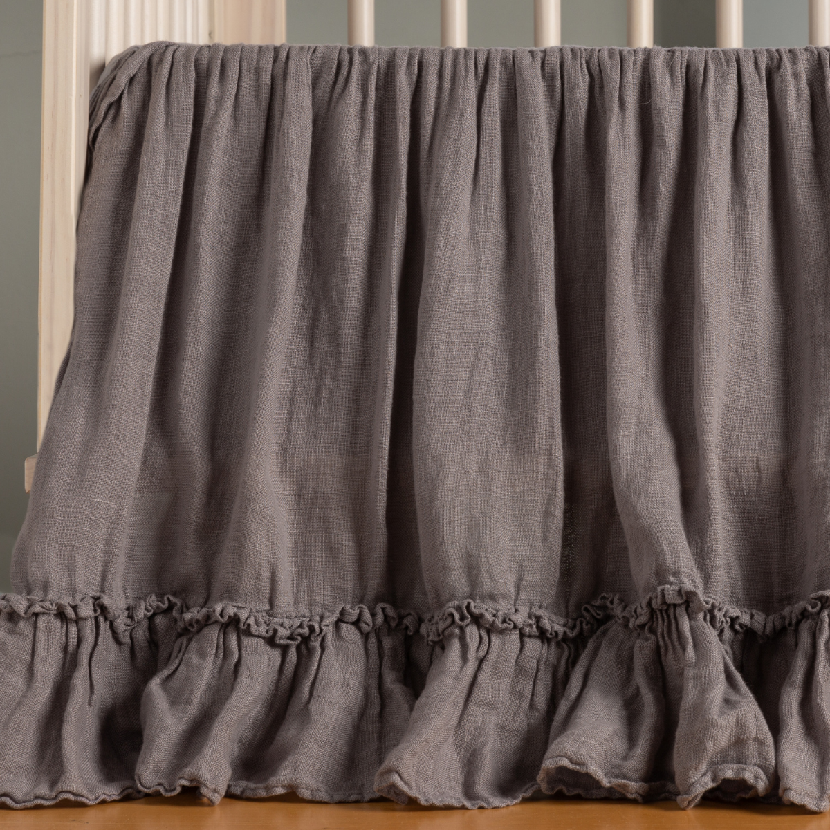 Bella Notte Linen Whisper crib skirt in French Lavender, showing ruffled hem detail.