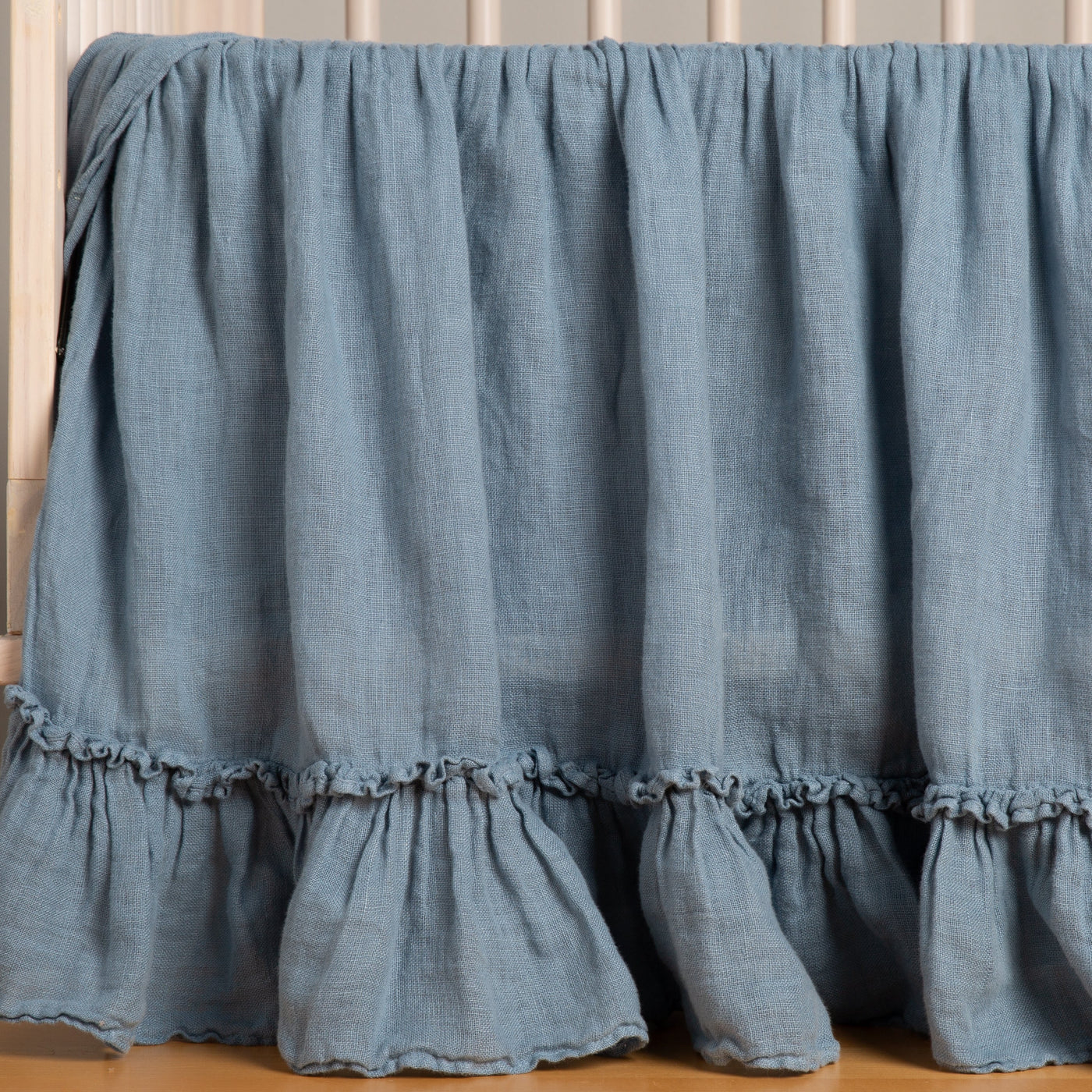 Bella Notte Linen Whisper crib skirt in Tahoe Blue, showing double ruffle hem detail.