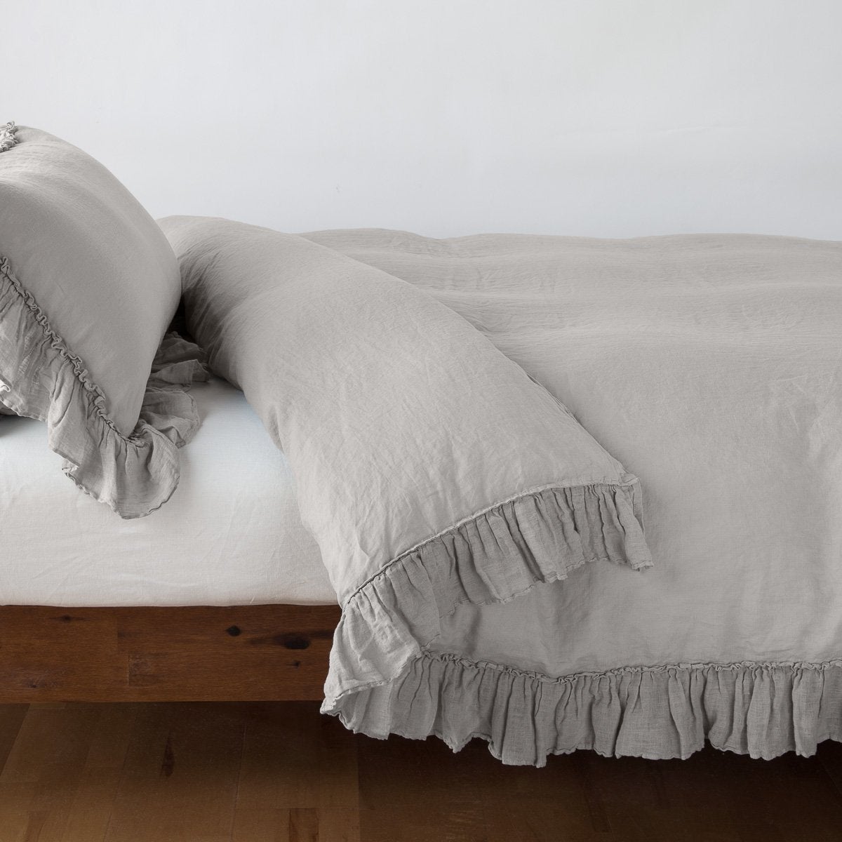 Fog Linen Whisper duvet cover draped over bed, ruffled trim detail visible at corner and hem.