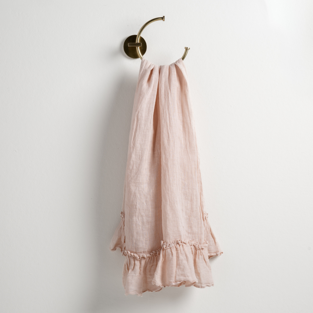 Bella Notte Linen Whisper guest towel in Pearl draped over brass ring, ruffled hem detail.