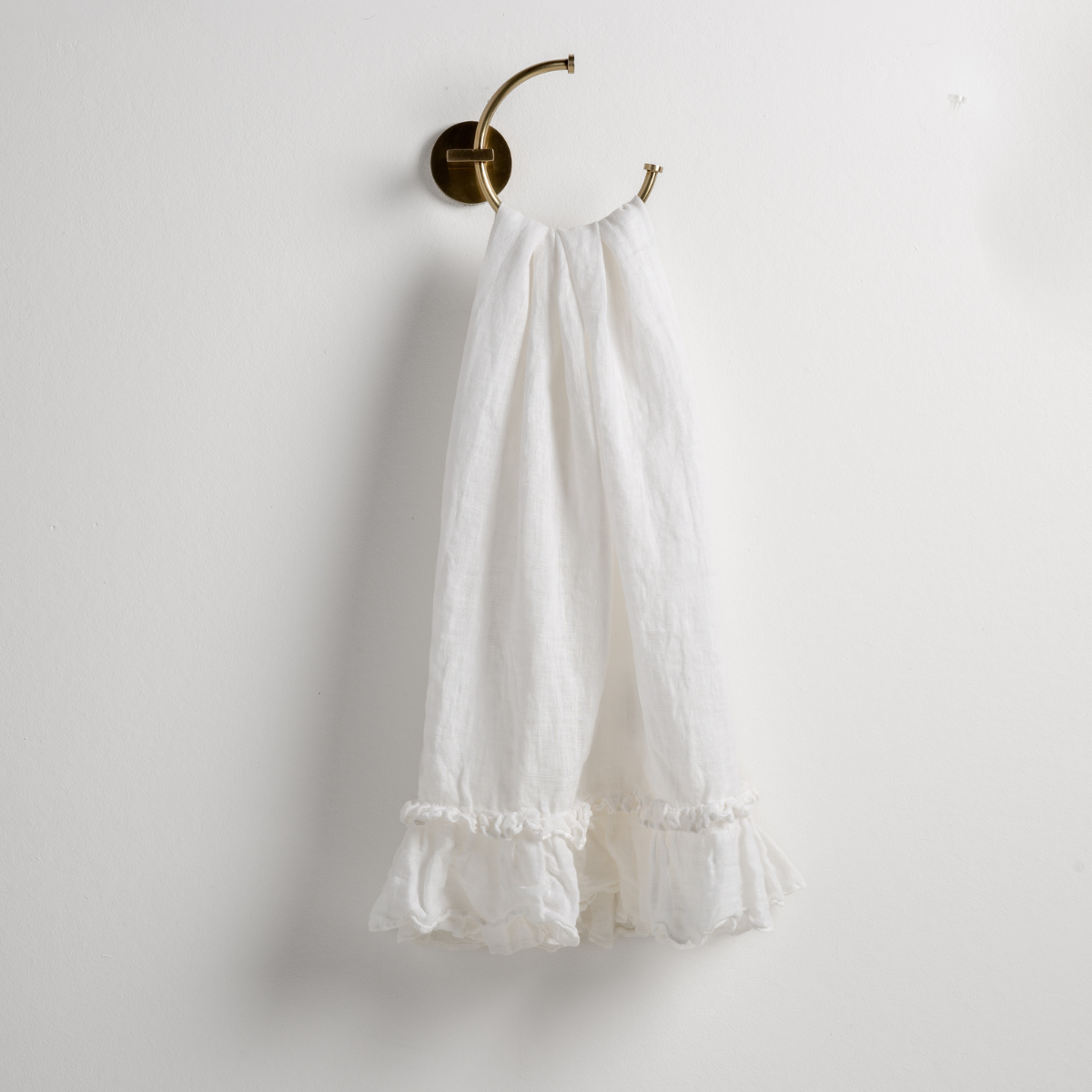 Bella Notte Linen Whisper guest towel in Winter White, ruffle hem detail on brass ring hook.