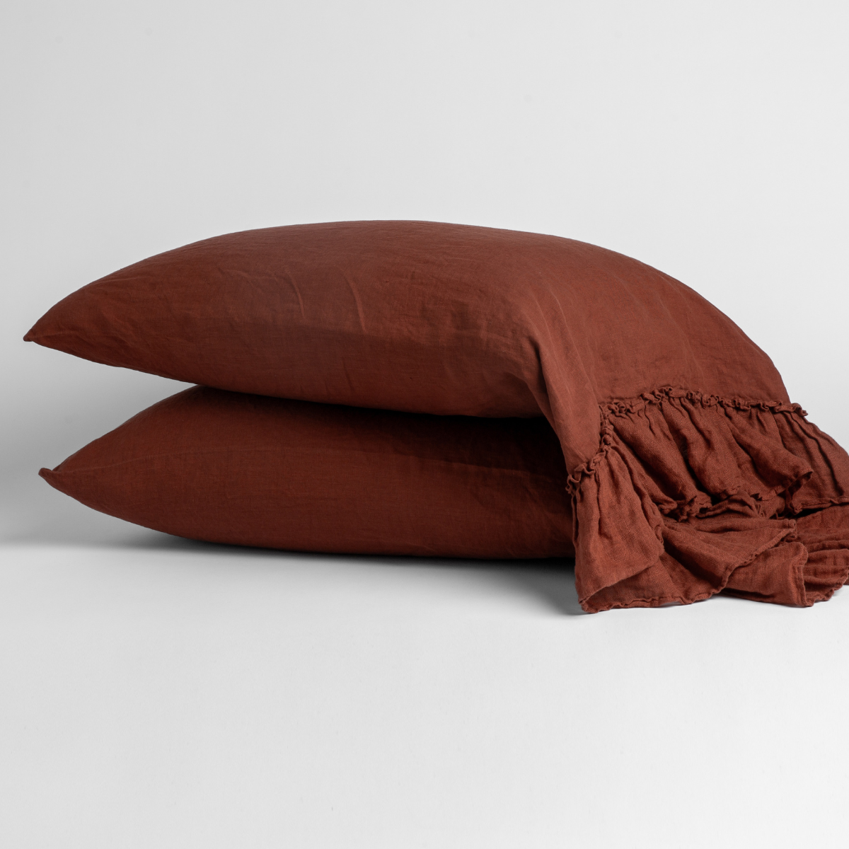 Two stacked Bella Notte Linen Whisper pillowcases in Autumn with ruffled edge detail.