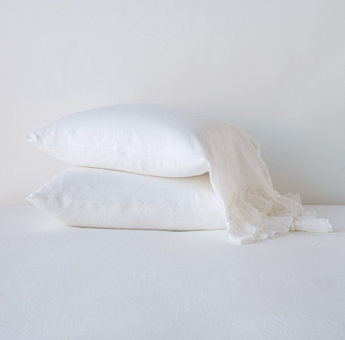 Bella Notte Linen Whisper pillowcase in White, two stacked with ruffled edge detail.