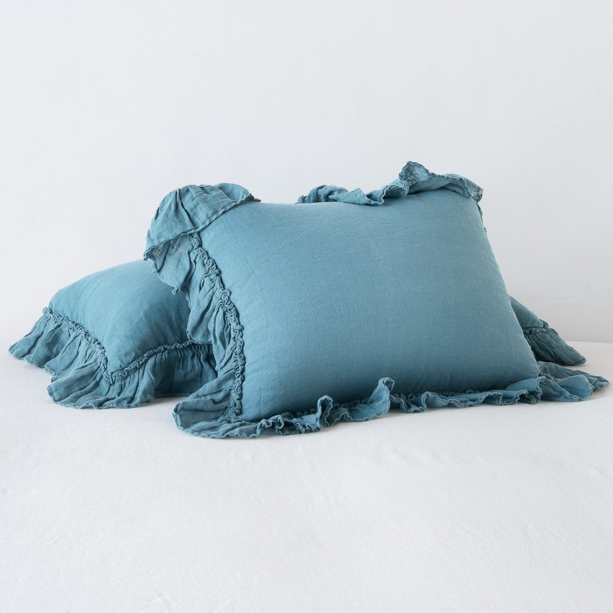 Cenote linen shams with ruffled edges, styled in a pair on a white surface.