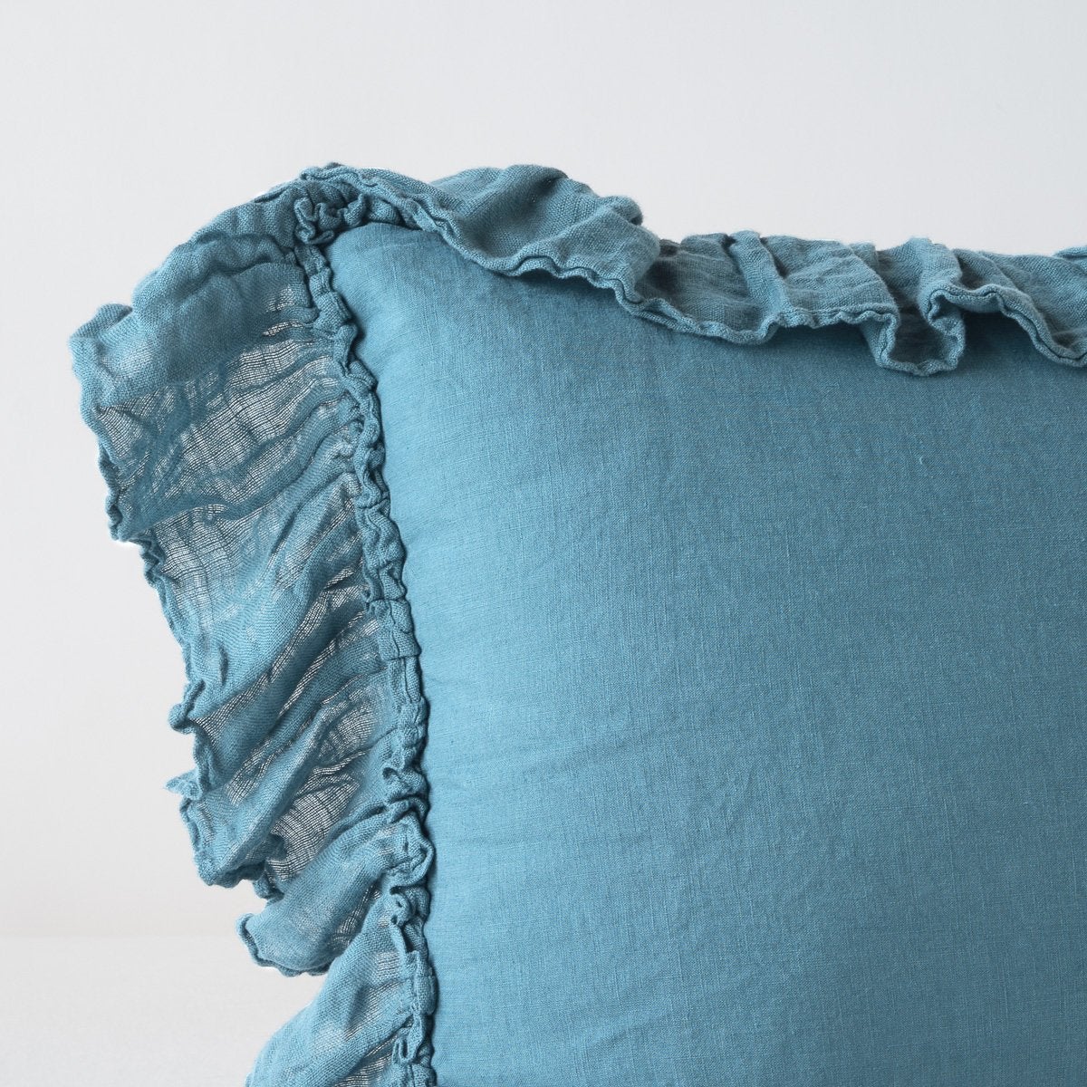 Close-up of Bella Notte Linen Whisper sham corner in Cenote with ruffled trim detail.
