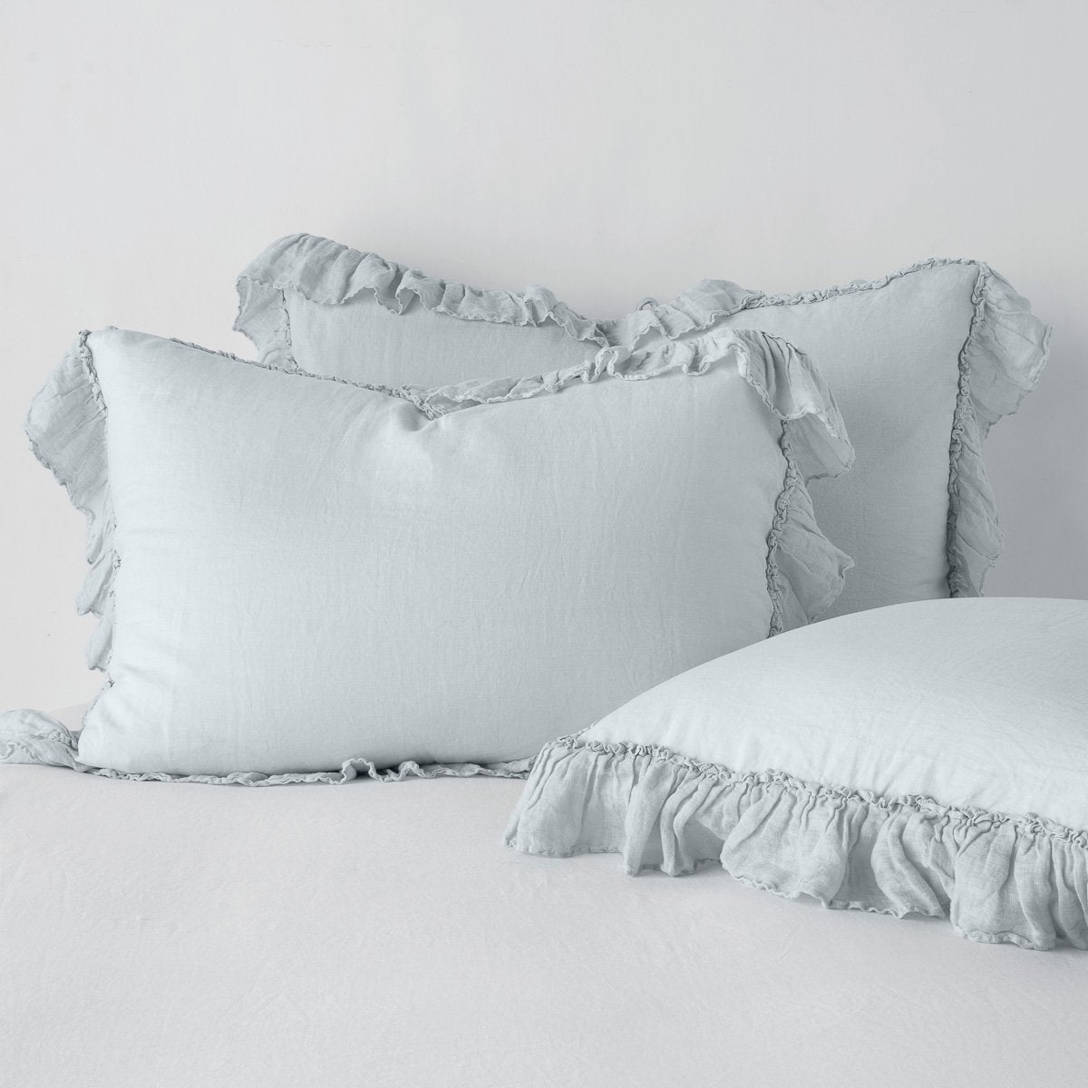 Bella Notte Linen Whisper shams in Cloud, showing ruffled trim detail and relaxed linen drape.