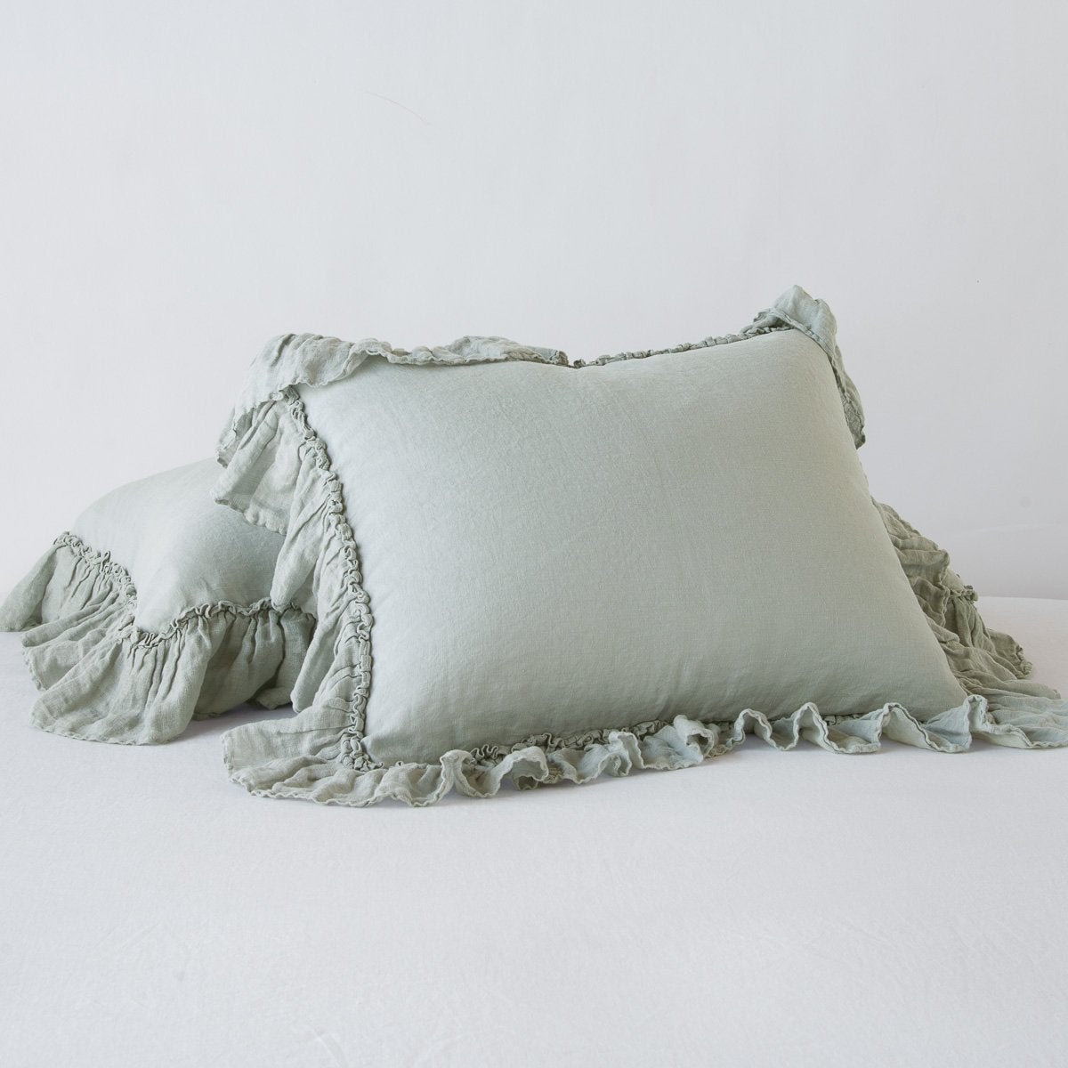 Ruffled edge detail on Bella Notte Linen Whisper sham in Eucalyptus, pair stacked.