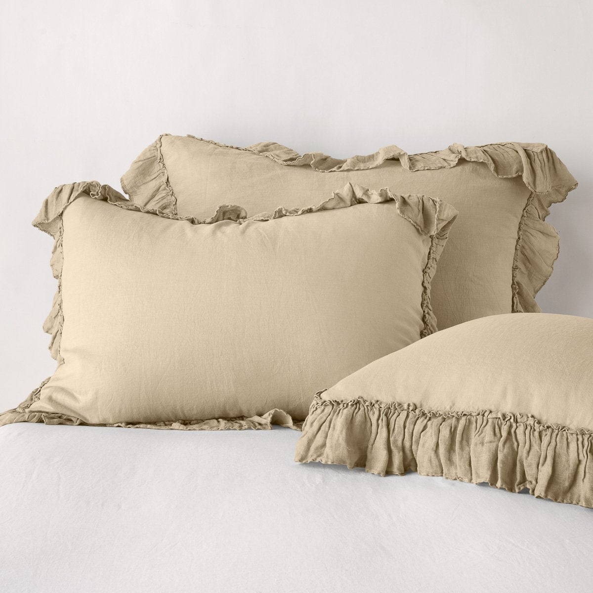 Three Bella Notte Linen Whisper shams in Honeycomb, styled on a bed, showing ruffled edges.