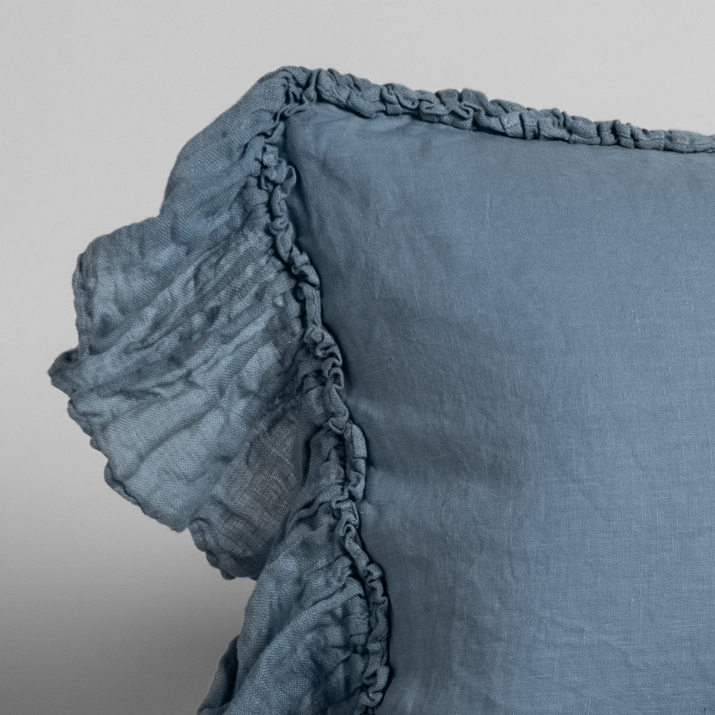 Close-up of Tahoe Blue linen sham corner with ruffled trim and gathered edge detail.
