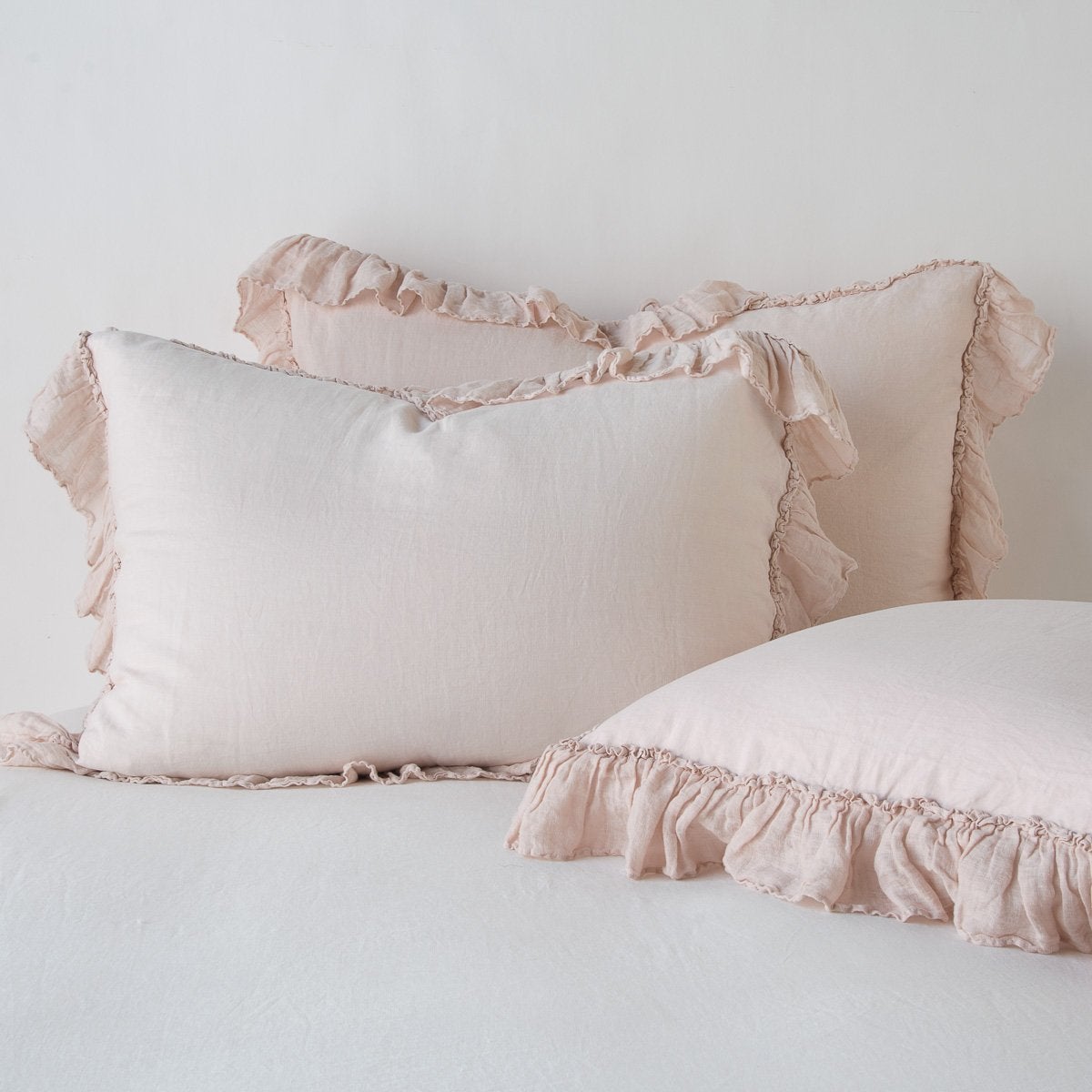 Bella Notte Pearl Linen Whisper shams styled on bed, showing ruffled edges in soft linen.