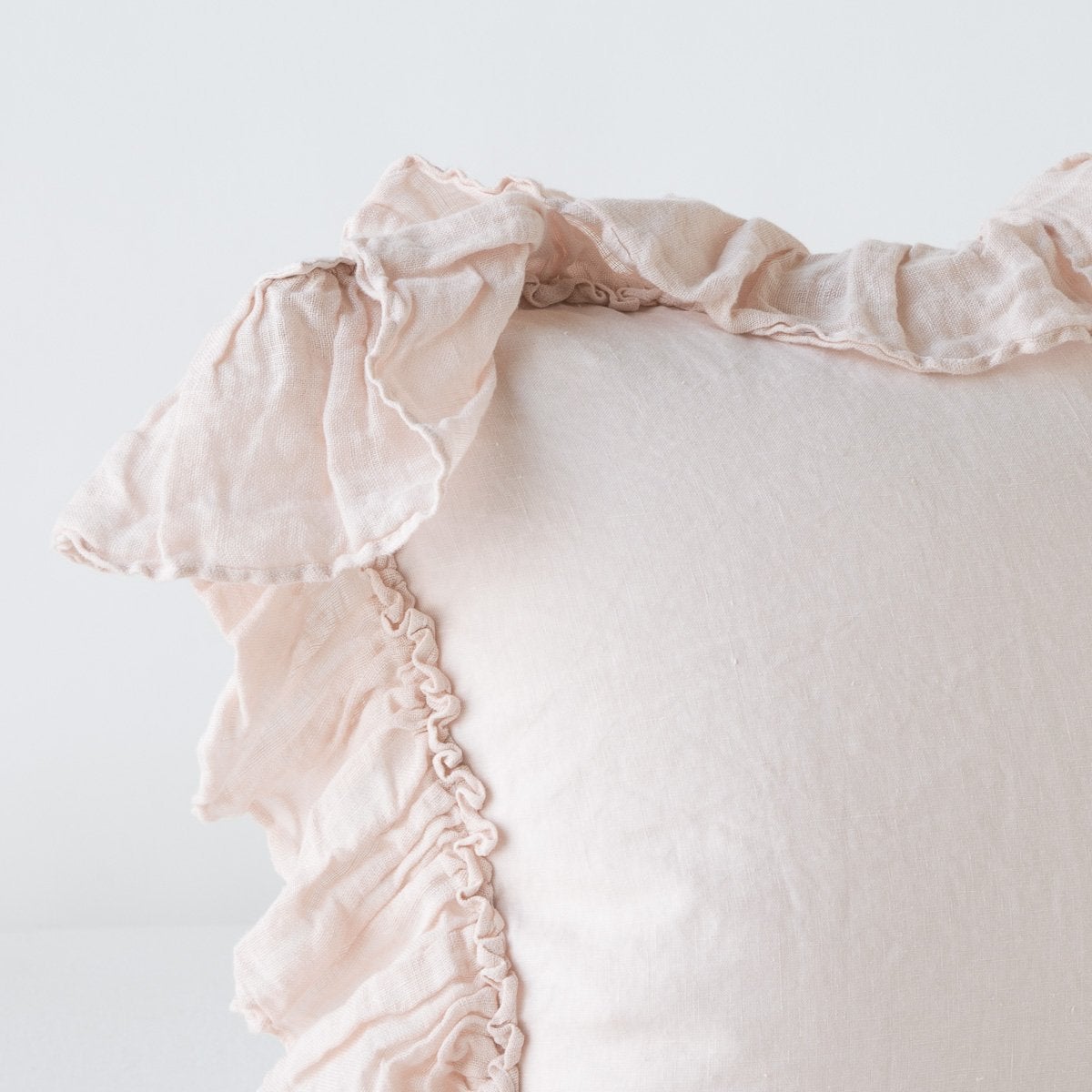 Close-up of Pearl linen sham corner with ruffled trim detail against a white background.