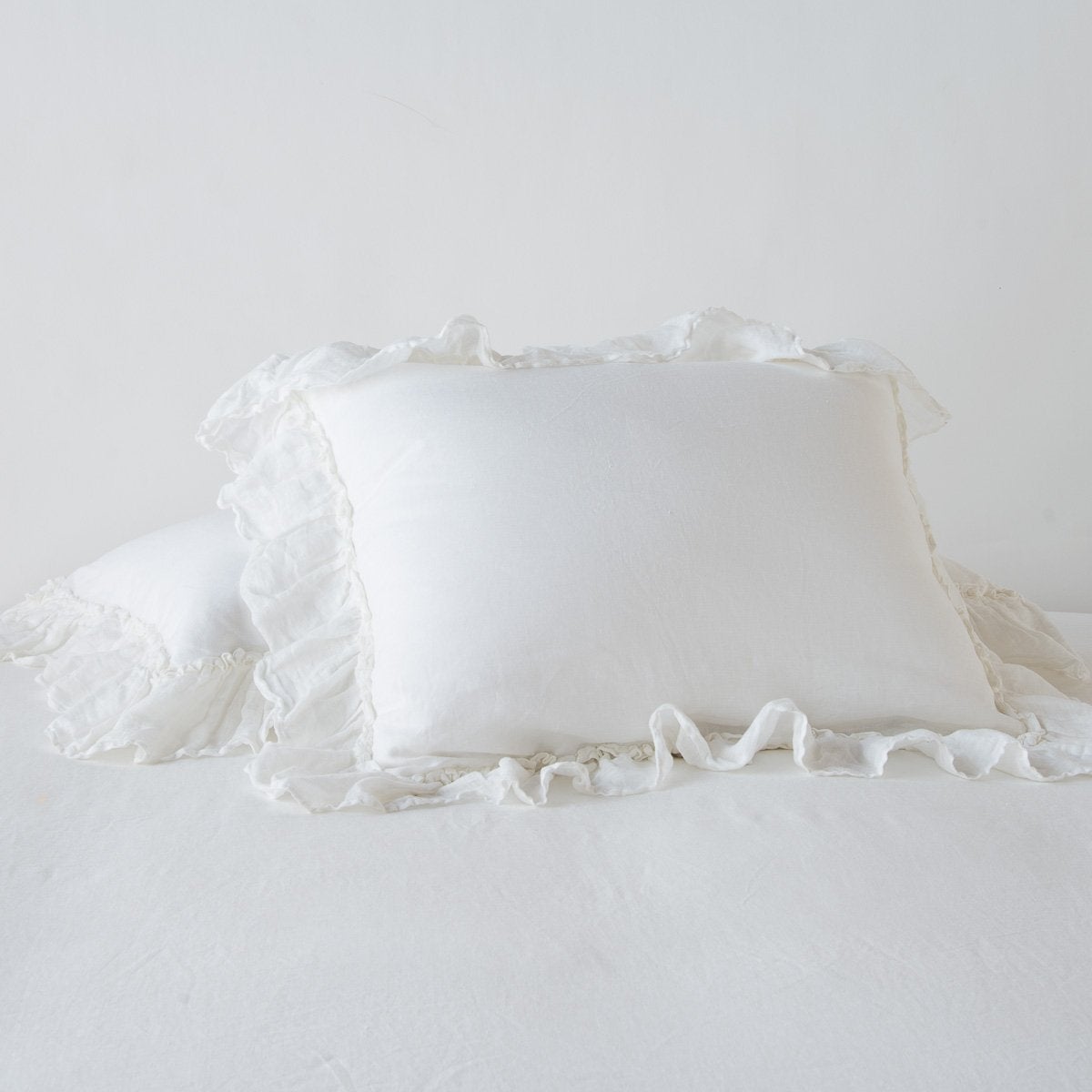 Bella Notte Linen Whisper sham in Winter White, side view showing ruffled edges on rumpled linen.
