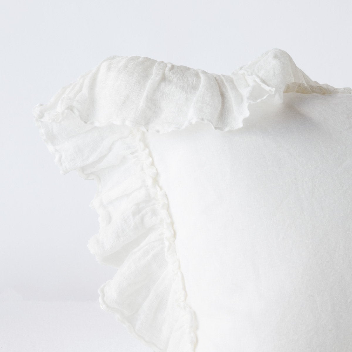 Close-up of Winter White linen sham corner with ruffled trim detail.