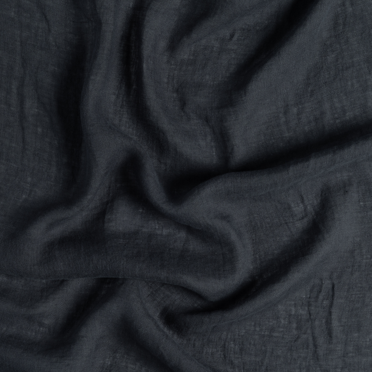 Slate linen fabric close-up showing soft drape and natural creased texture.