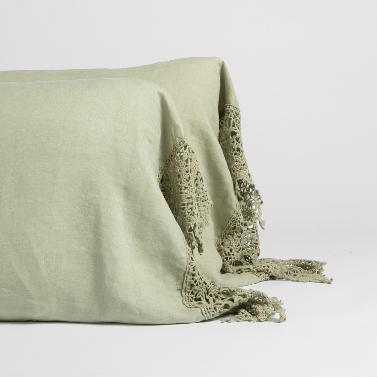 Close-up of Desert Sage linen pillowcase edge with intricate crochet lace trim detail.