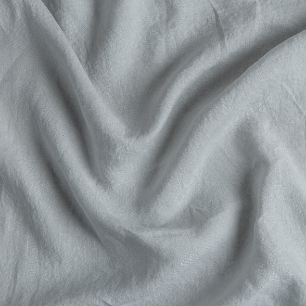 Close-up of Bella Notte Cloud linen pillowcase fabric showing soft drape and texture.