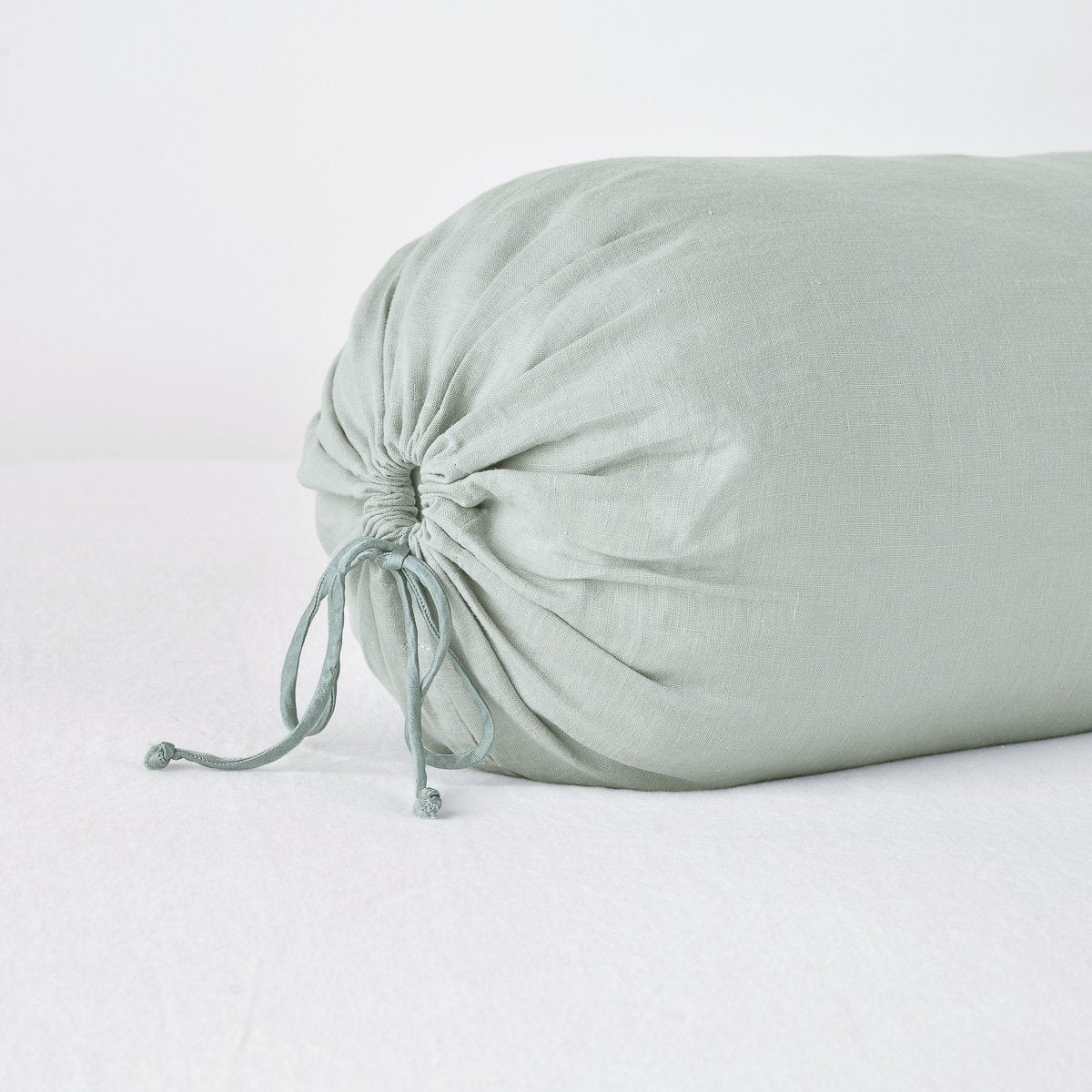 Close-up of Bella Notte Linen Throw Pillow drawstring end detail in Eucalyptus.