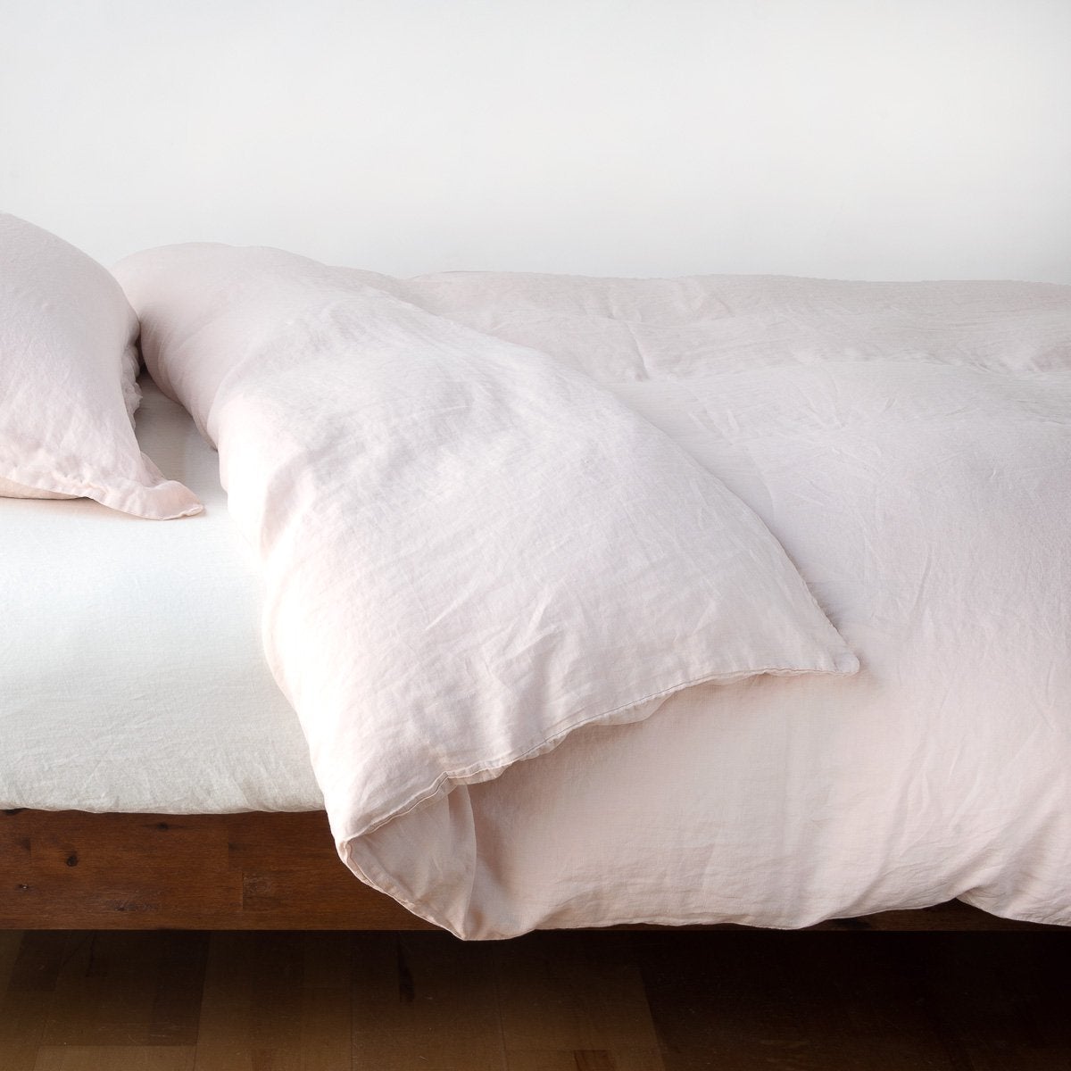 Bella Notte Linen duvet cover in Pearl, relaxed drape detail on wood platform bed.